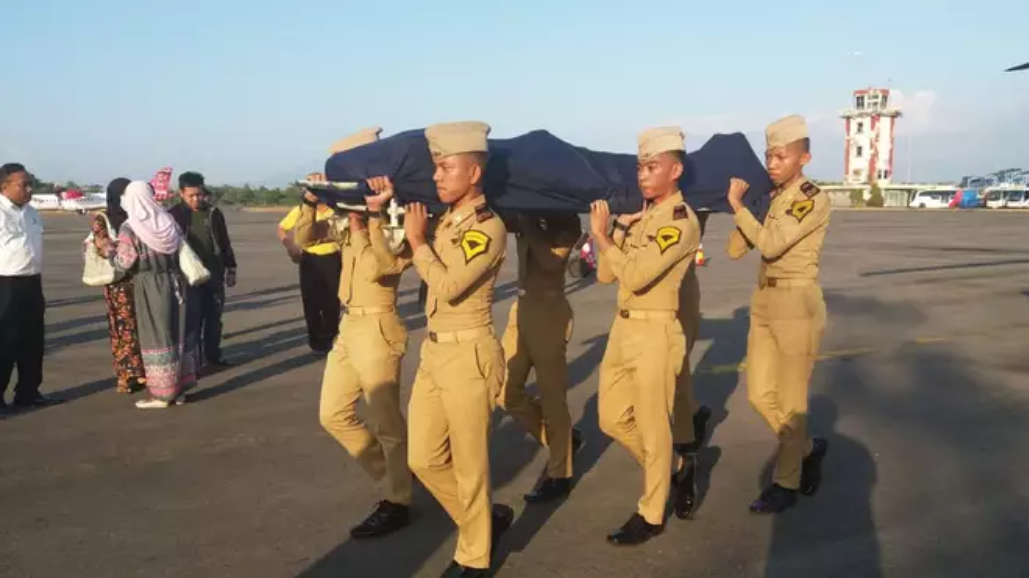 Indonesian soldiers carrying the body of Agung