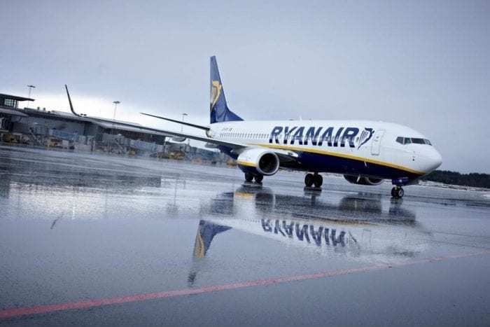 Ryanair airliner on apron in rain 
