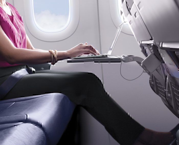 A passenger uses a laptop onboard an aircraft. 