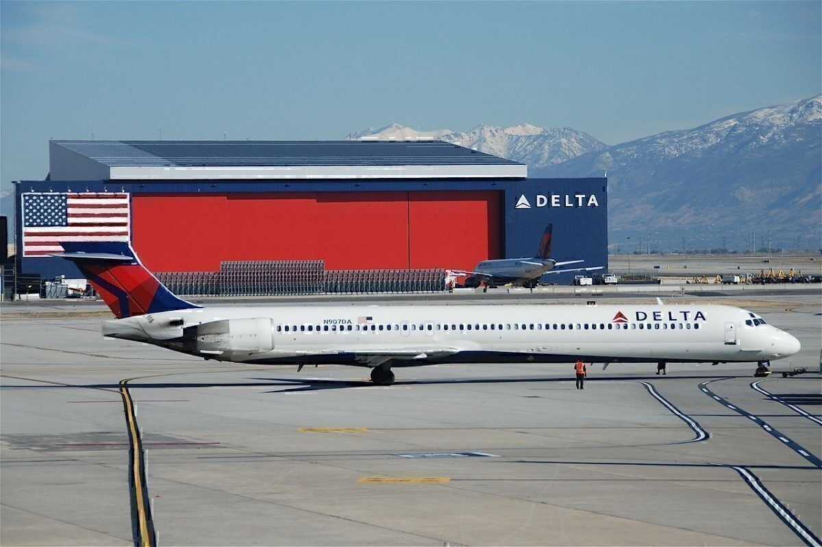 A Delta MD-90 aircraft taxiing on a runway.