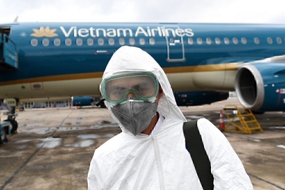 Vietnam airlines worker in mask disinfecting plane