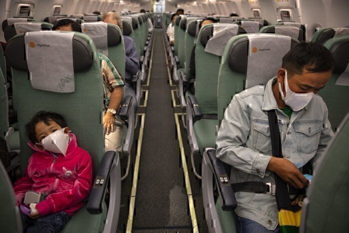 Father and son wearing masks on a plane during the coronavirus outbreak