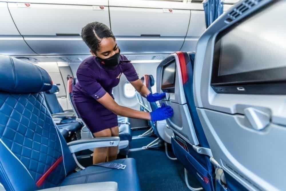 Delta staff member cleans aircraft