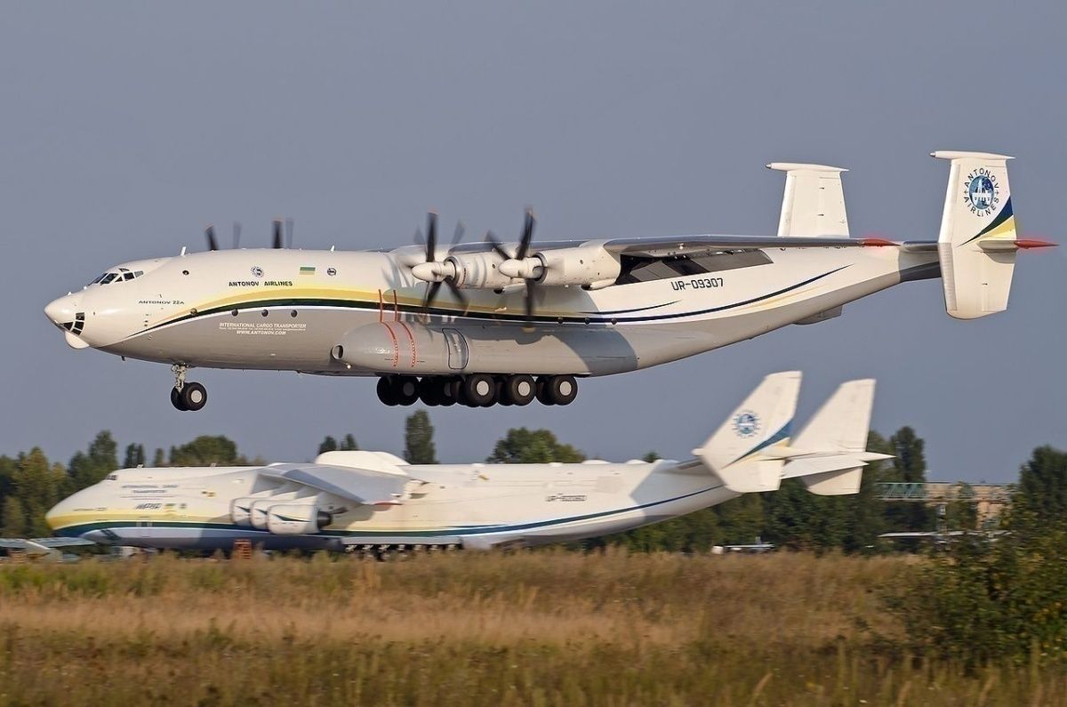 An An-22 landing at Gostomel Airport, with the An-225 parked in the background.