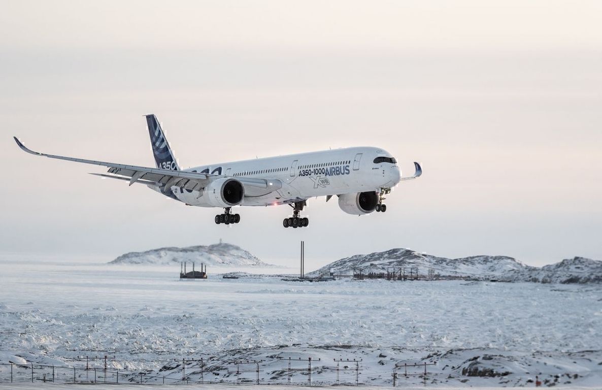 An A350-1000 about to touch down on a snowy runway.