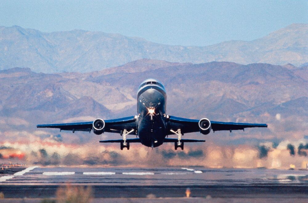 Lockheed L-1011 Tristar taking-off with mountains behind.