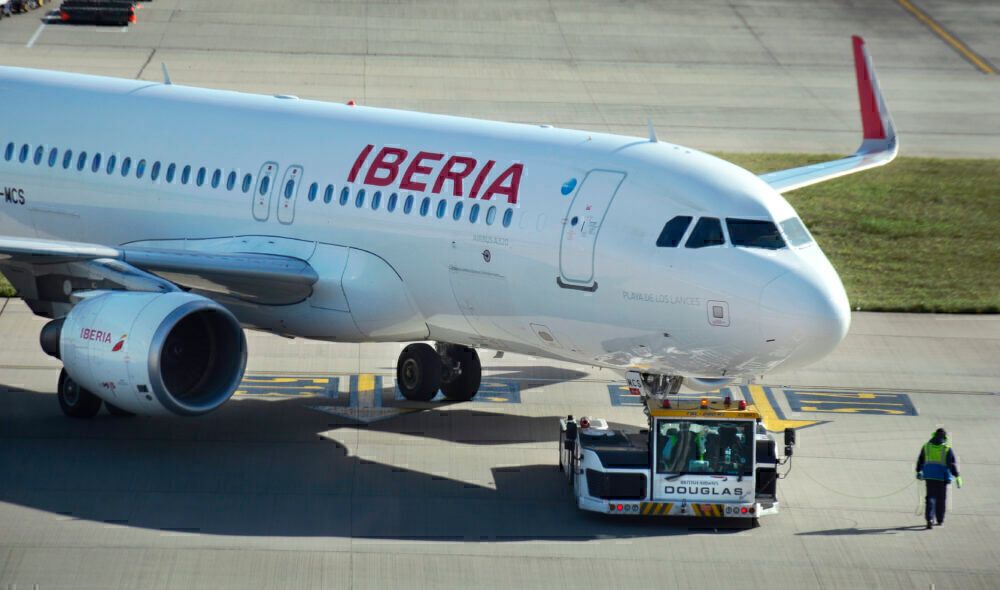Iberia aircraft on pushback by tug at airport