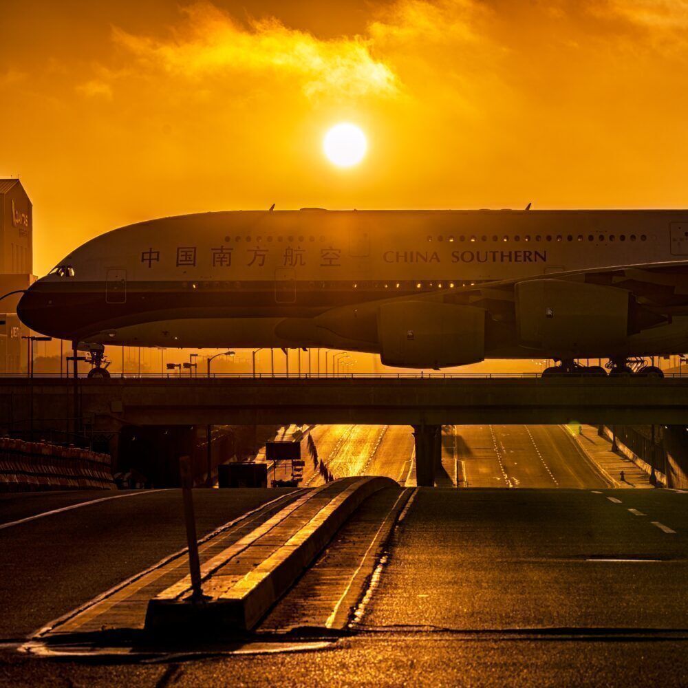 China southern A380 crosses a bridge in front of the setting sun
