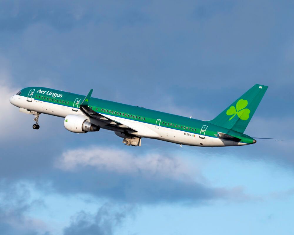 An Aer Lingus Boeing 757-2Q8, registration EI-LBS, flying low below the clouds. 