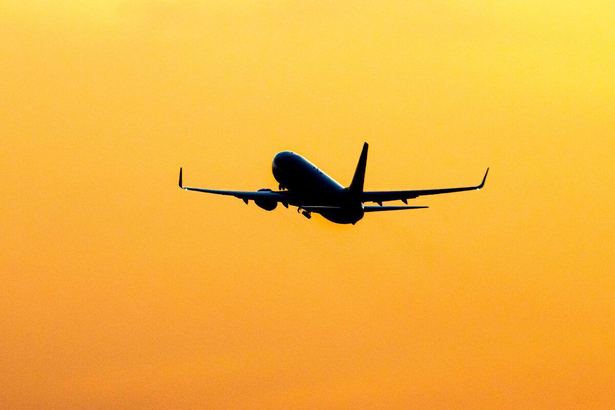 Silhouette Of A Departing Aircraft During Sunset