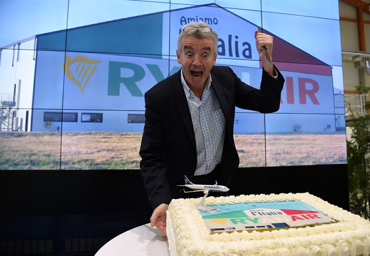 Michael O'Leary standing over a cake