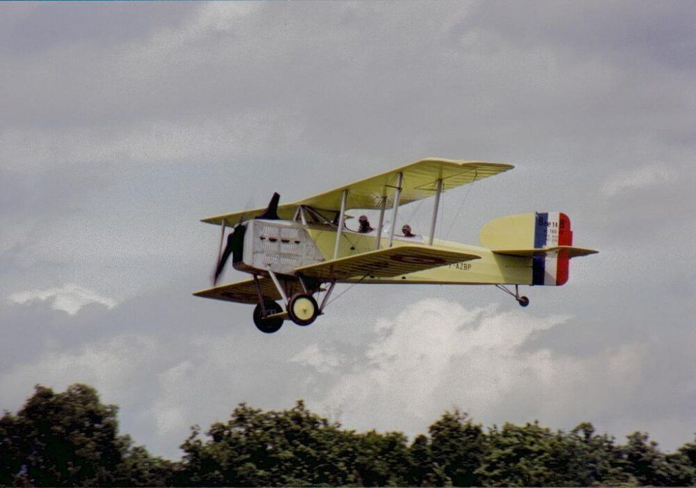 A warbird replica flying in the sky.
