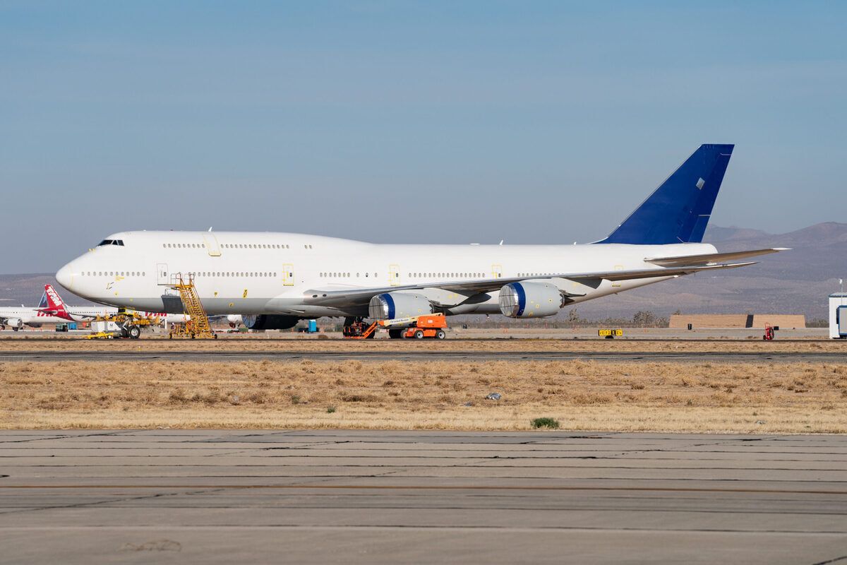 A Boeing 747-8 with no livery parked at a desert.