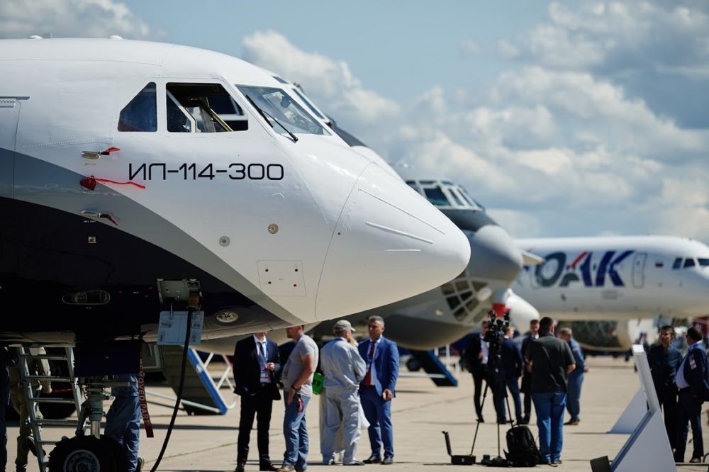 Side view of the Ilyushin IL-114-300, surrounded by spectators.
