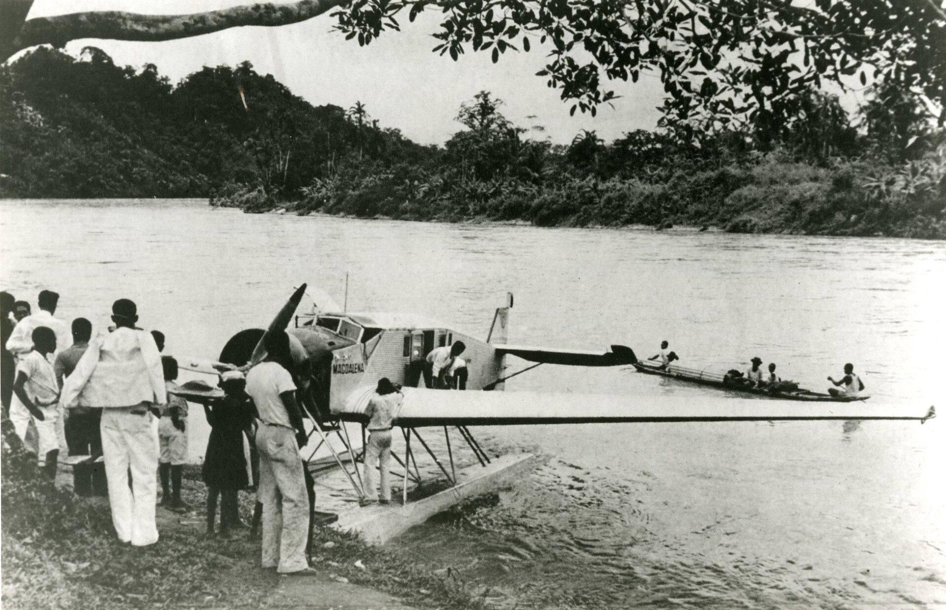 A Junkers W 34 parked in water surrounded by people.
