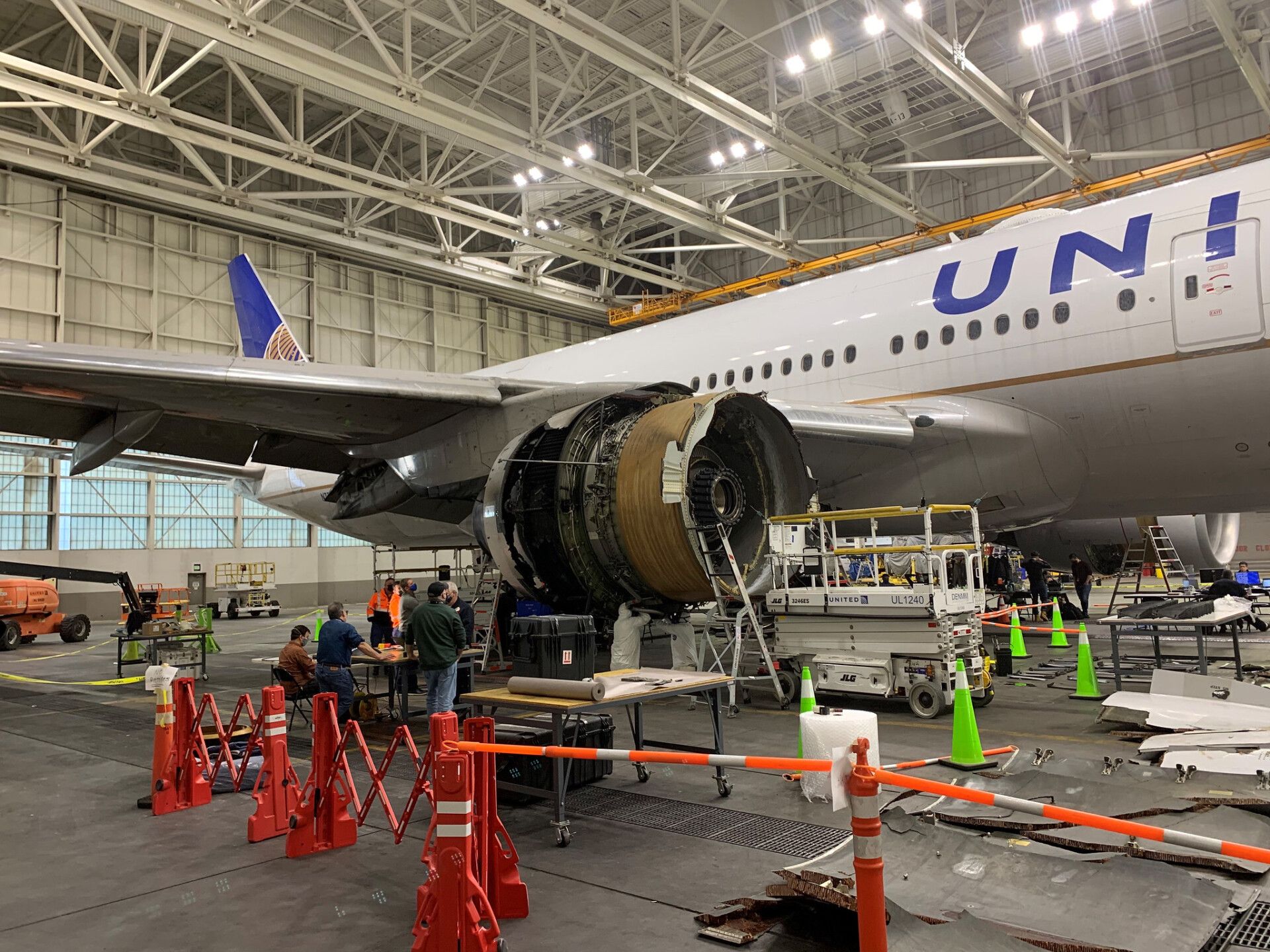 A United Airlines Boeing 777 with a broken engine being examined in a maintenance facility.