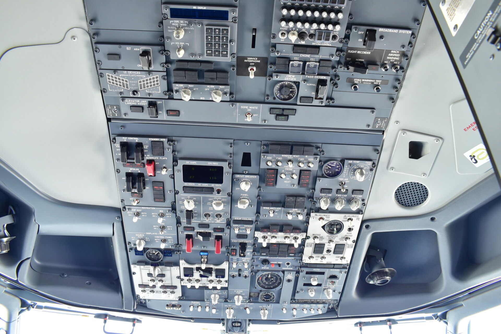 Many buttons and switches on the top of an airliner cockpit.