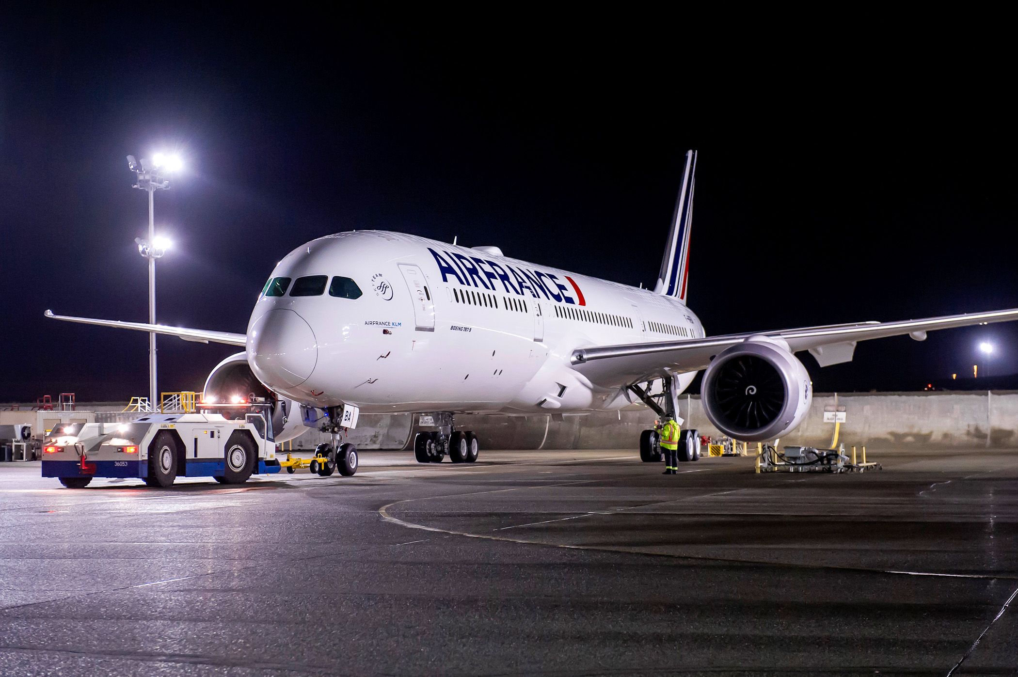 An AirFrance Boeing 787 being pushed back at an airport.