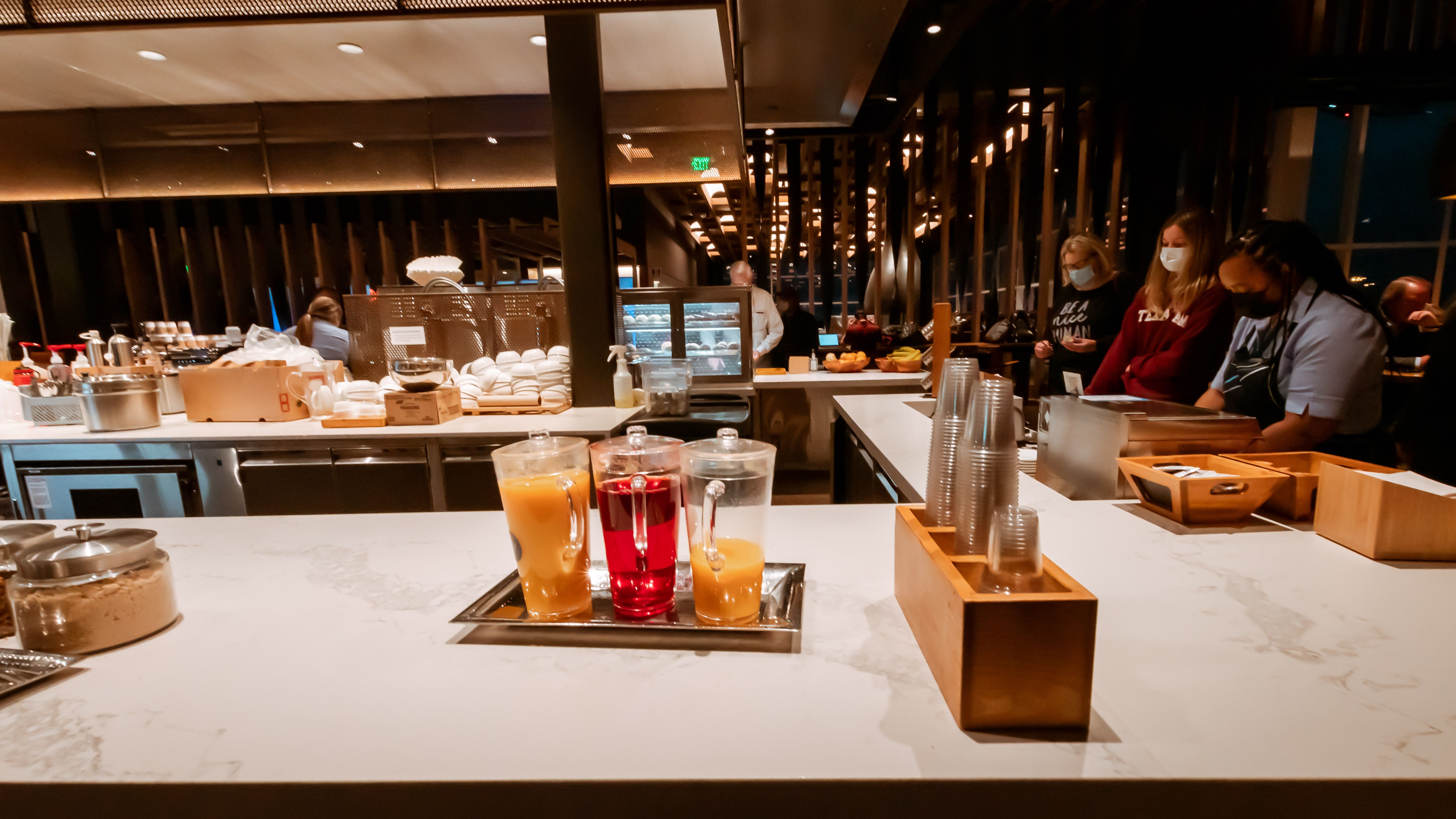 A Well Stocked Alaska Airlines Lounge - With Juices, Cups and Guests