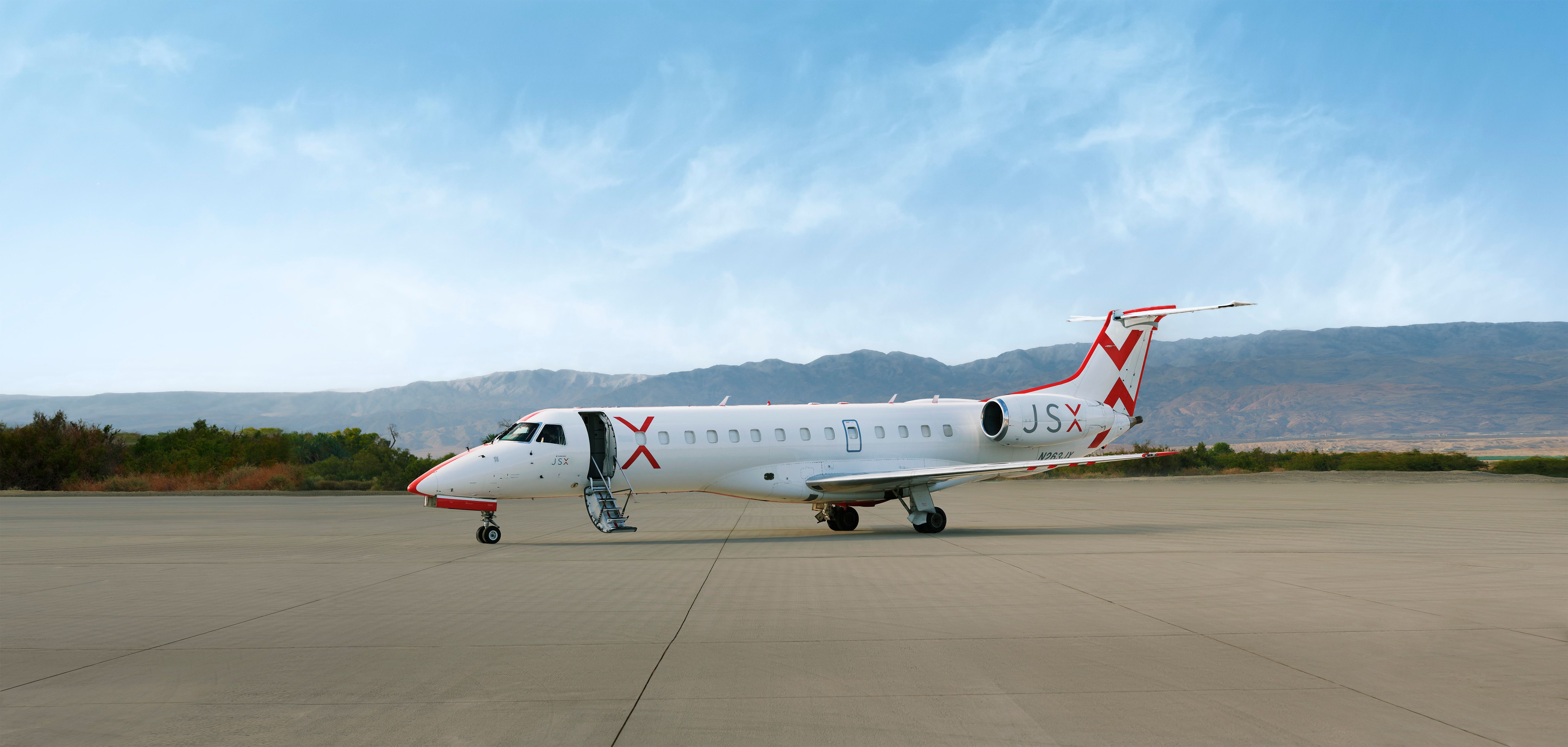 A JSX Embraer jet parked at an airport.