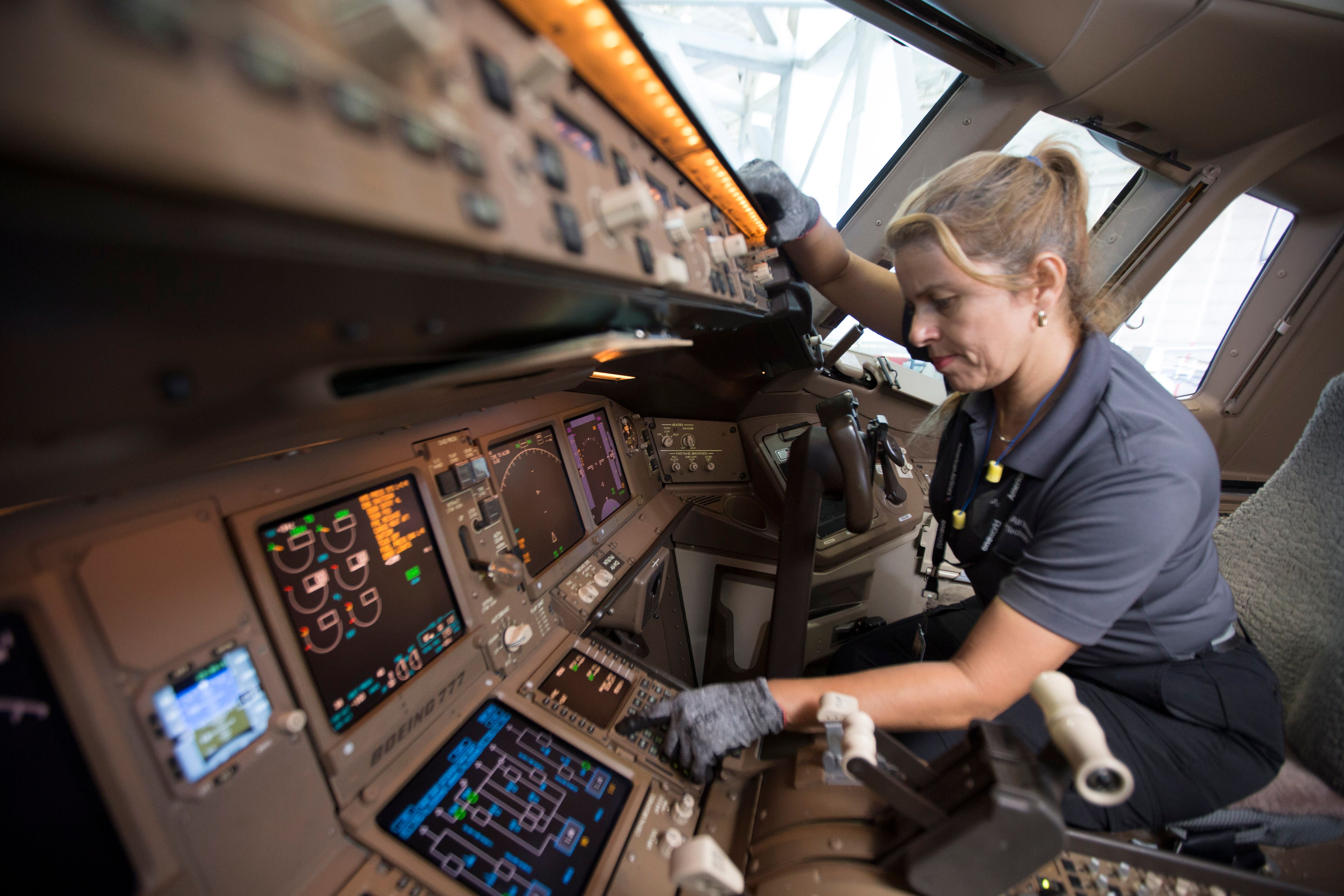 A Maintenance technician working in an aircraft cockpit.
