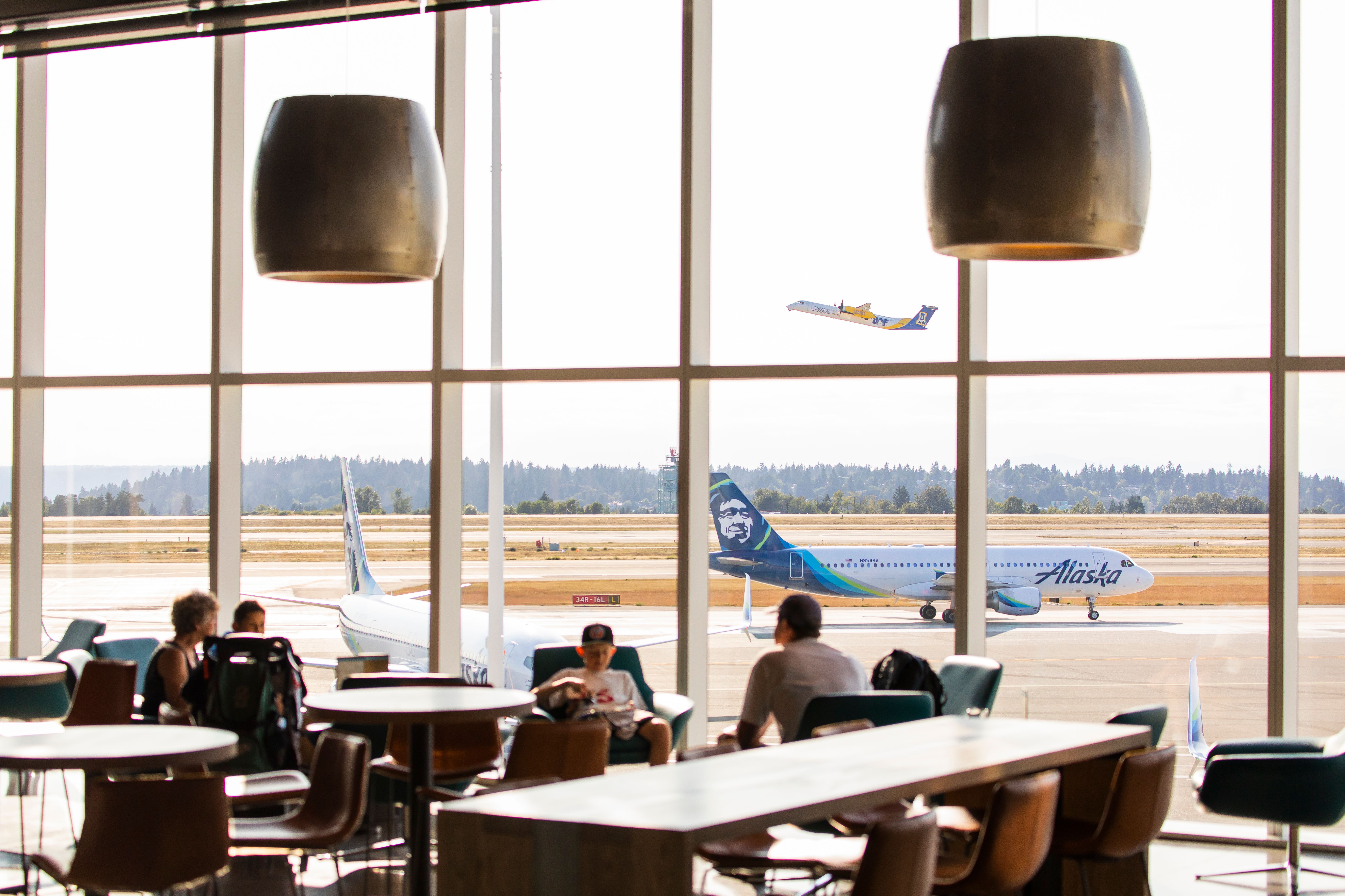 Alaska Airlines Lounge Guests Relaxing At An Active Airport