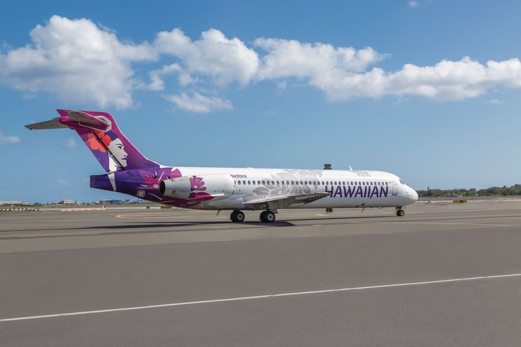 A Hawaiian Airlines Boeing 717 taxiing at an airport.