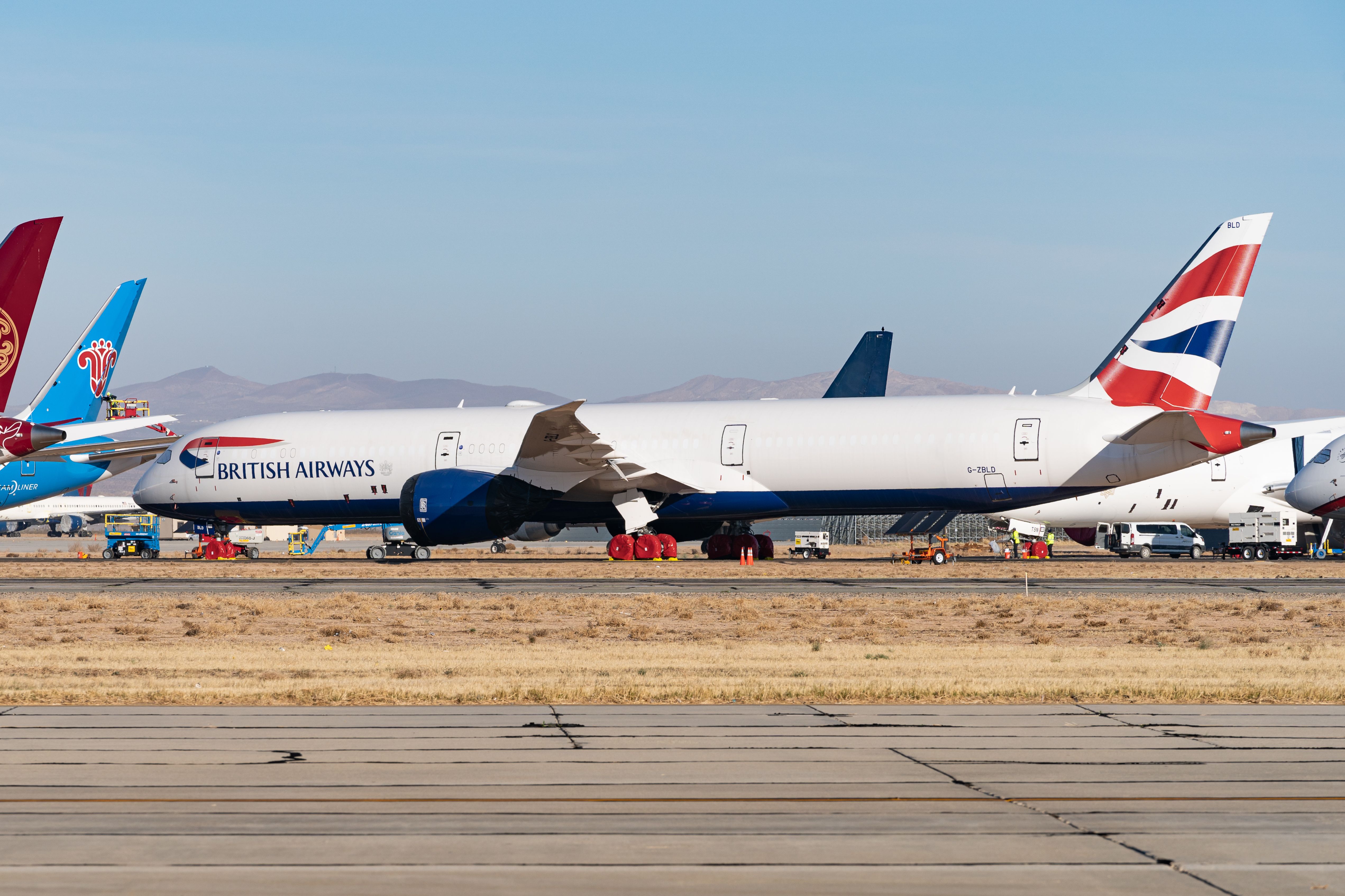 A retired British Airways Boeing 787-10 Dreamliner parked near several other aircraft from other airlines.