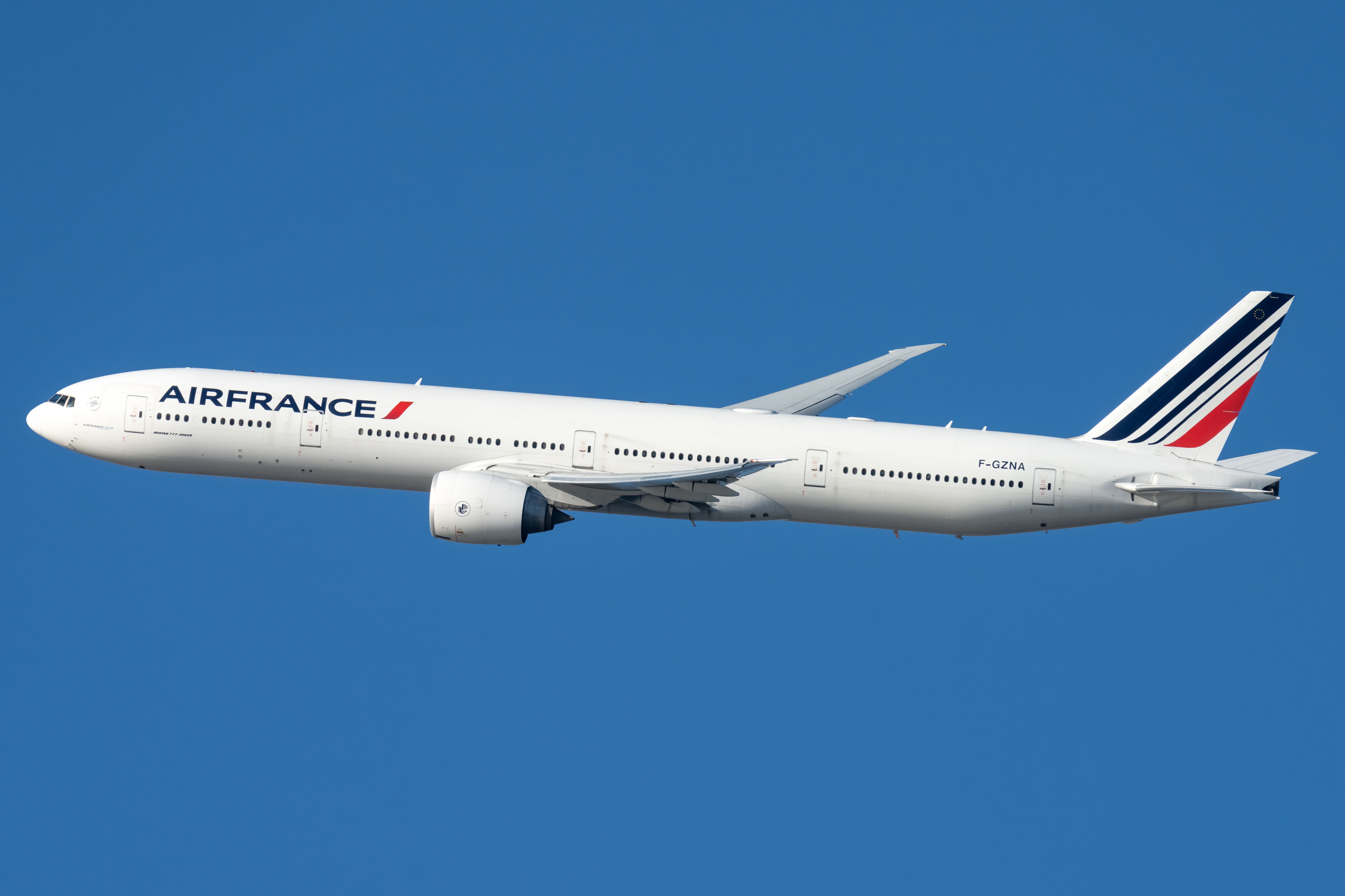 Air France Boeing 777-300 photographed in flight in front of a blue sky.