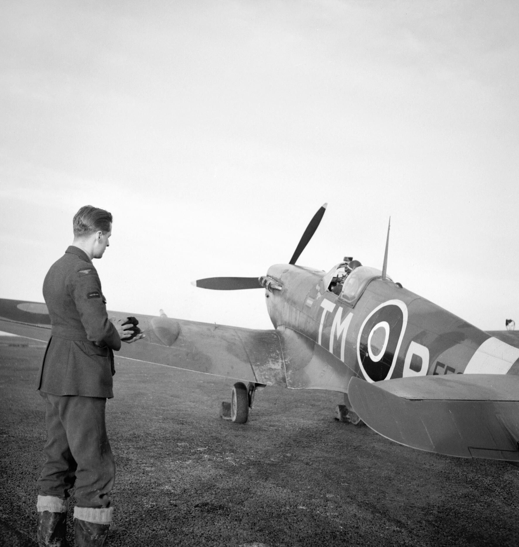 An_engine_fitter_watches_the_CO_of_No._504_Squadron,_Squadron_Leader_R._Lewis,_in_his_Spitfire_Mk_VC_at_Middle_Wallop,_December_1942._CH8010