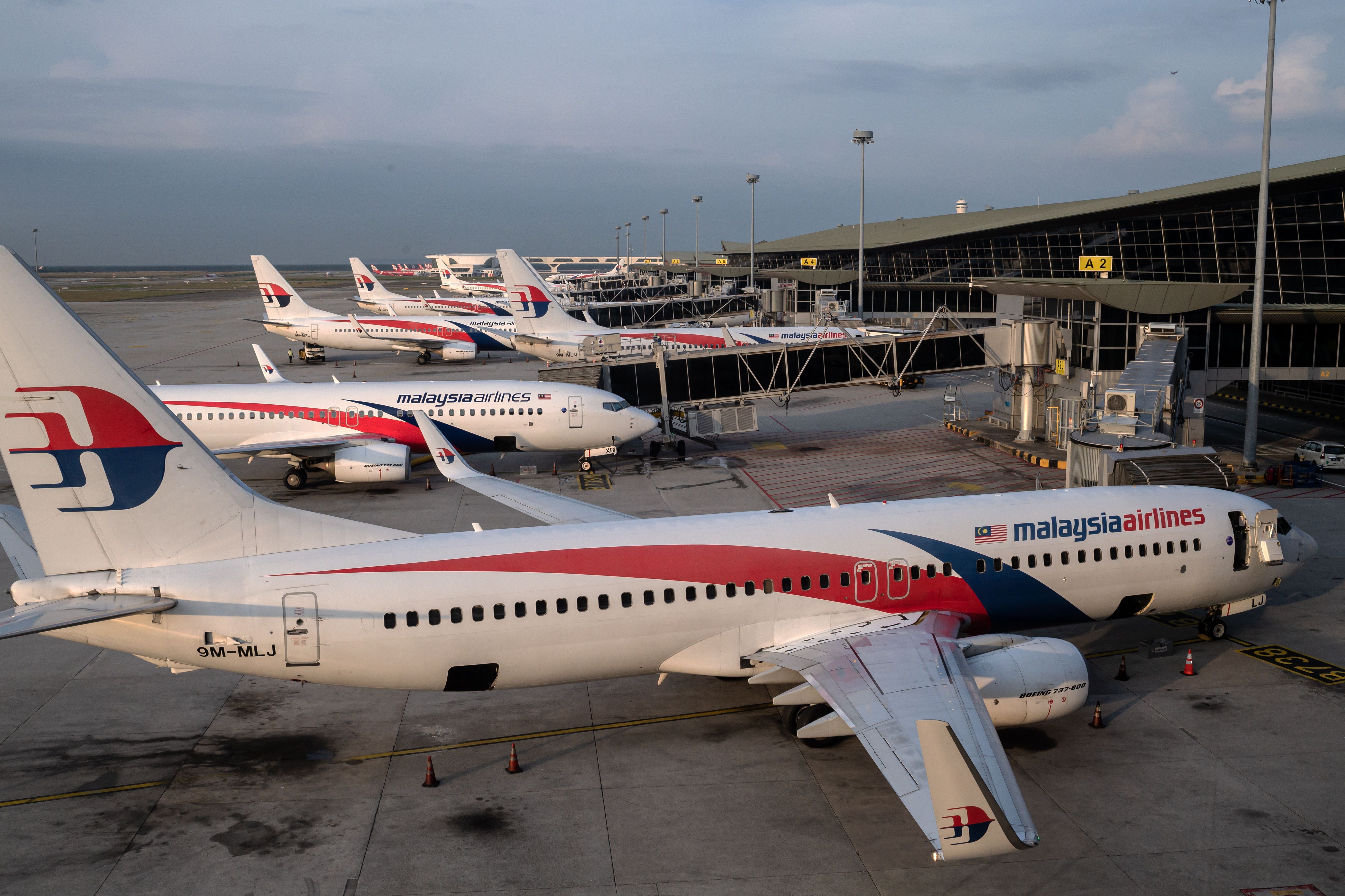 Malaysia Airlines aircraft parked by terminal