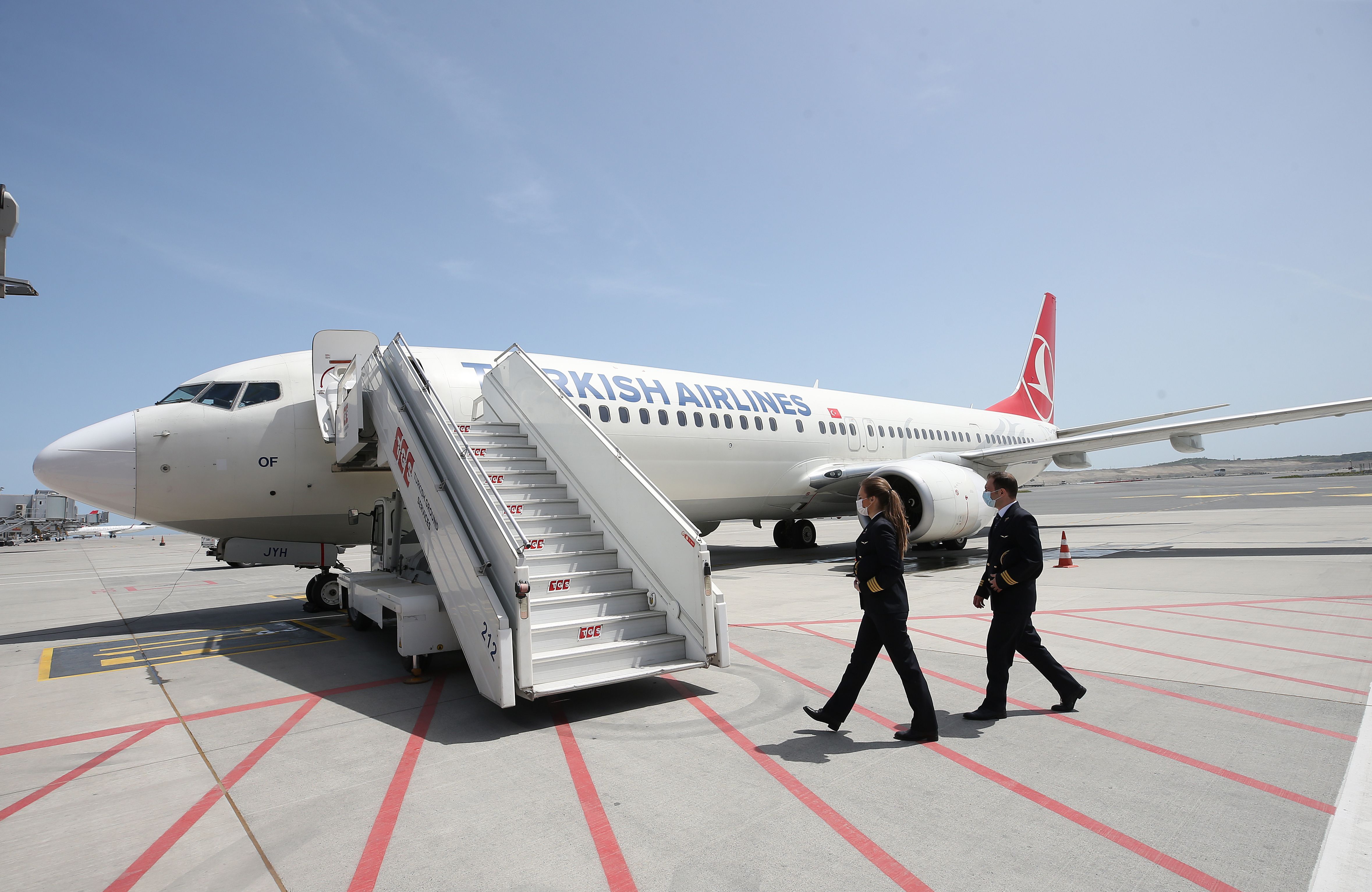 Two pilots are seen walking across the ramp to a Turkish Airlines Boeing 737.