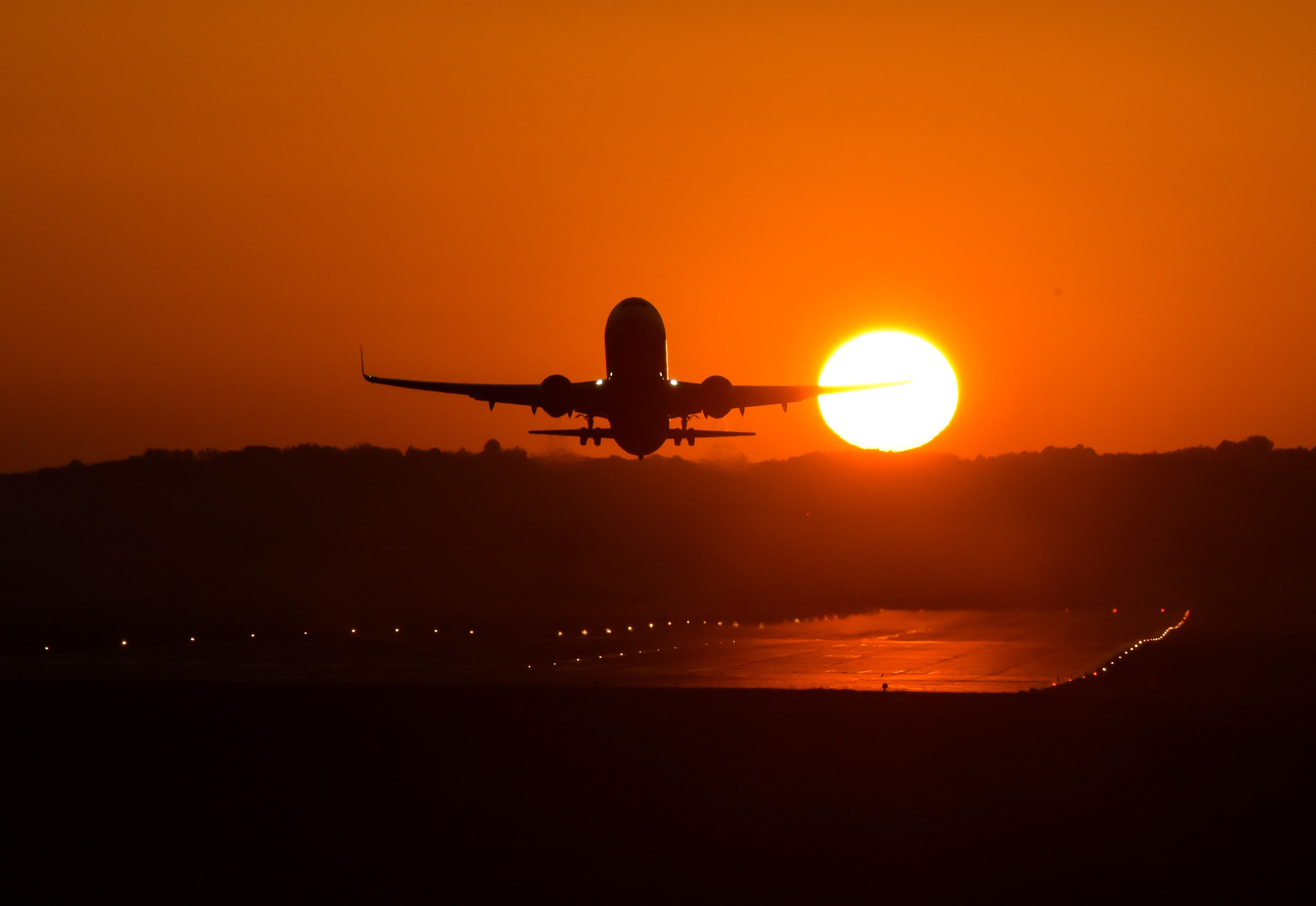 Aircraft taking off at sunset