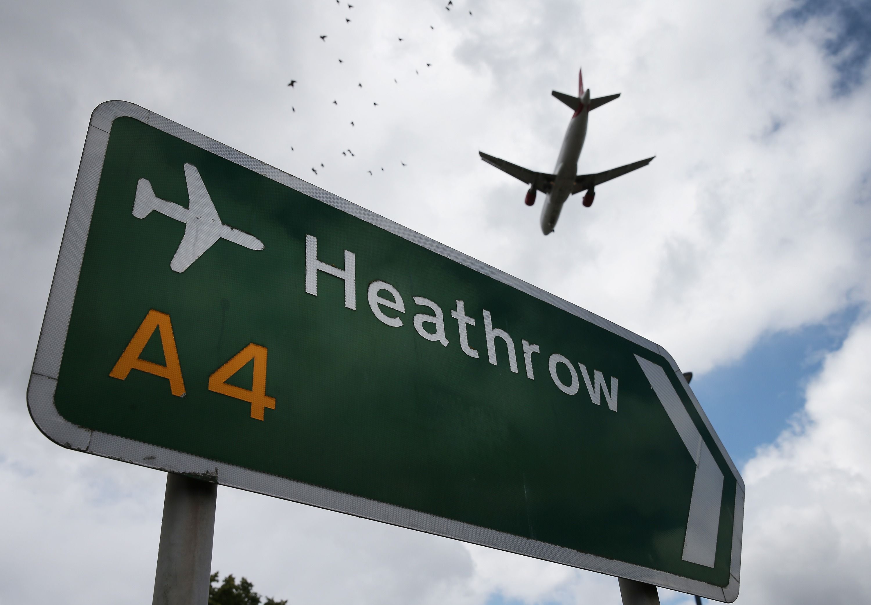 Heathrow sign with aircraft flying above