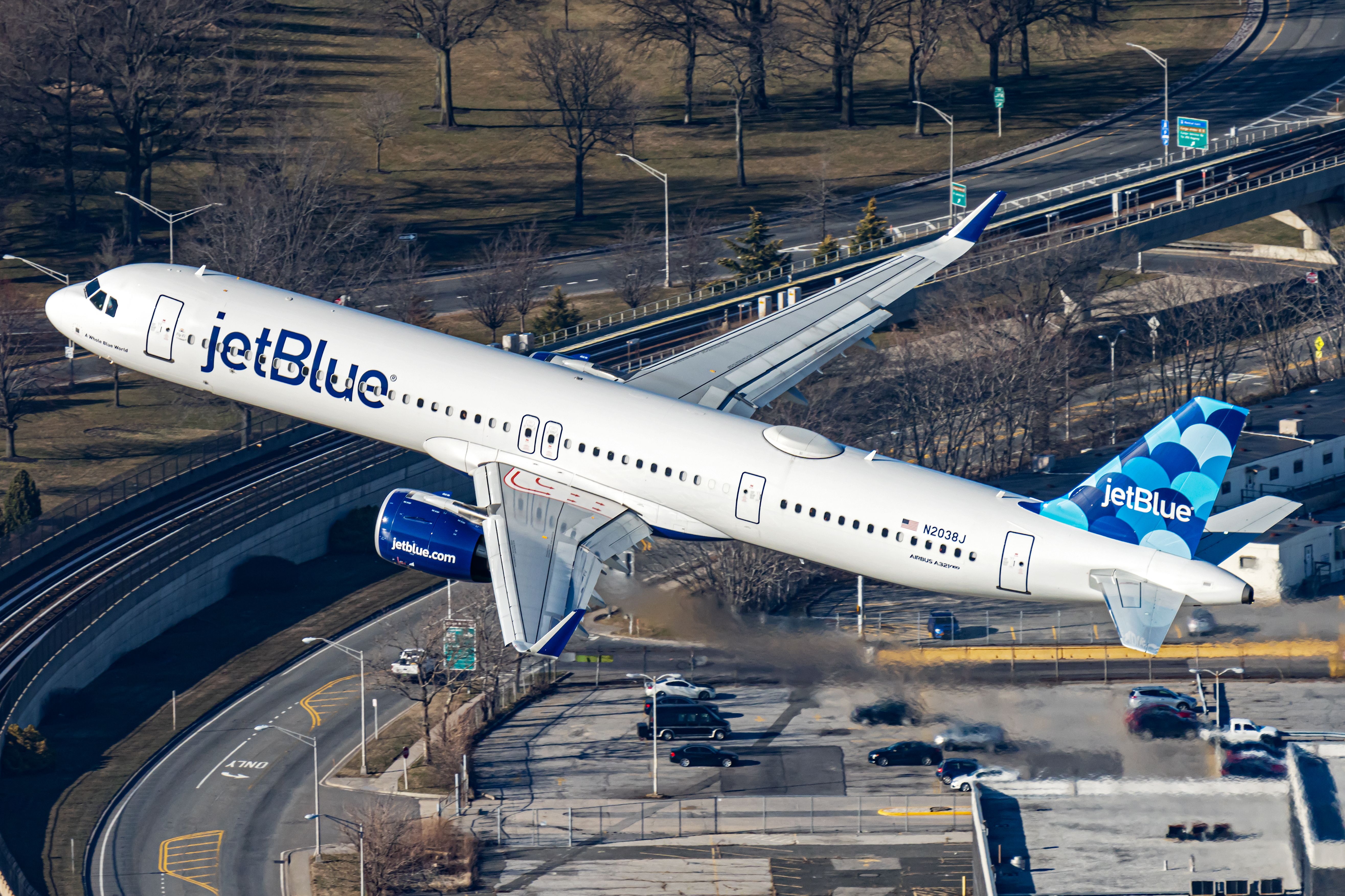 JetBlue Airways Airbus A321 taking off over a highway 