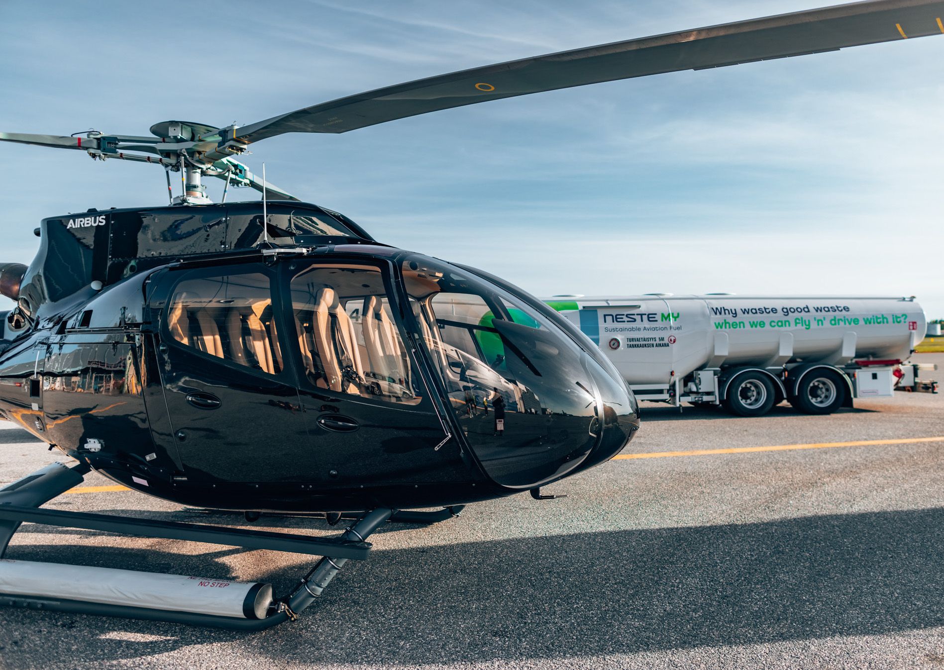 Airbus helicopter on apron with Neste refueling truck in the background