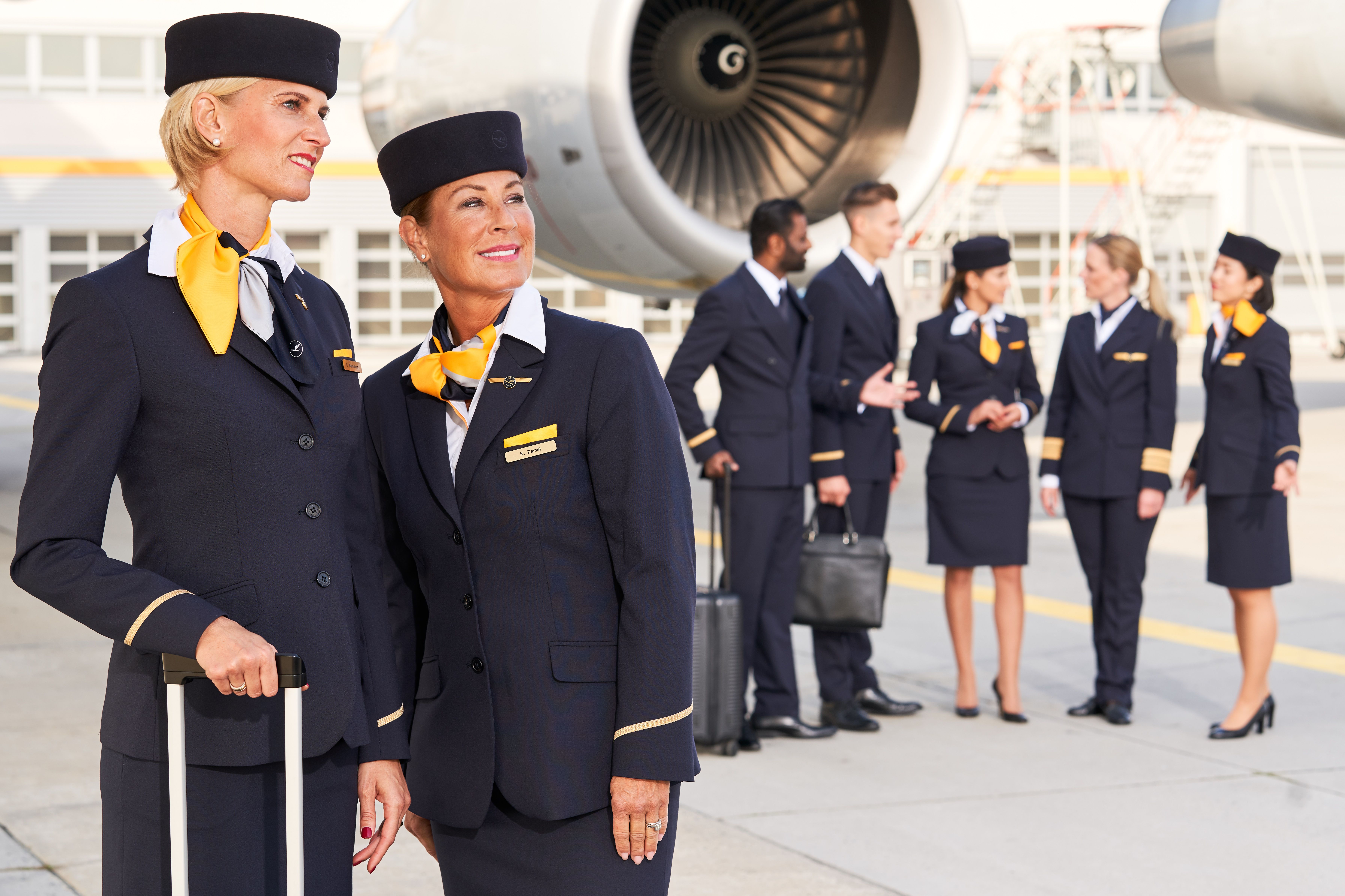 Lufthansa cabin crew standing in front of jet