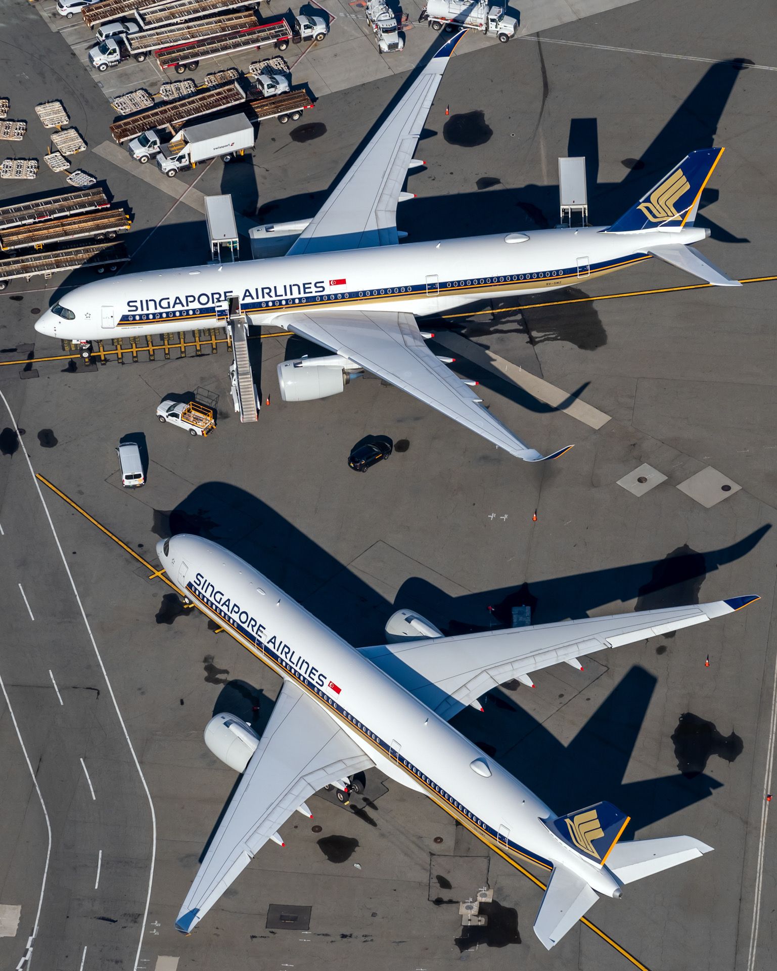 Two Singapore Airlines Airbus A350s parked at an airport.