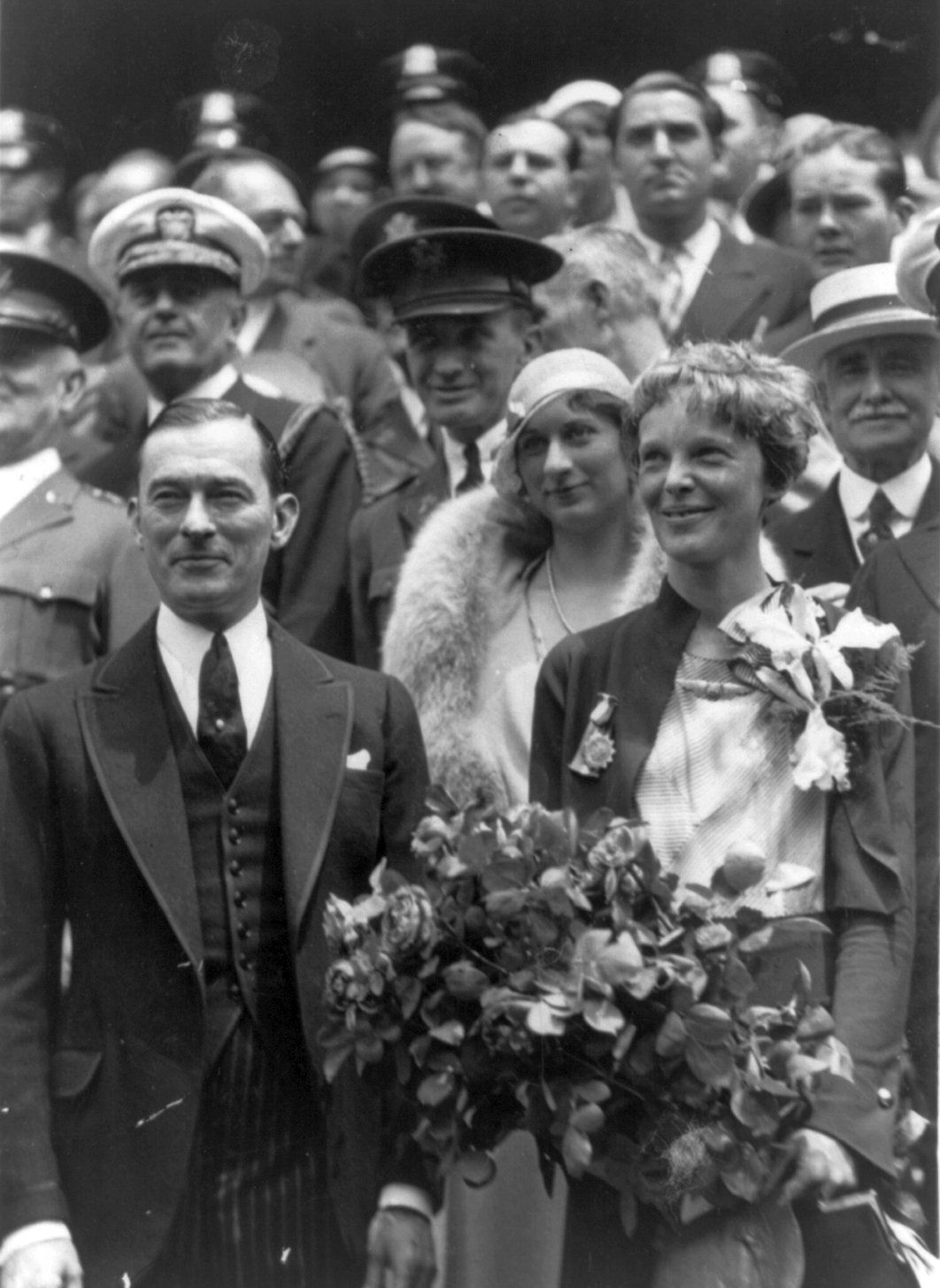 Amelia Earhart, 1898-1937, half-length portrait, standing with Mayor James Walker of New York holding roses