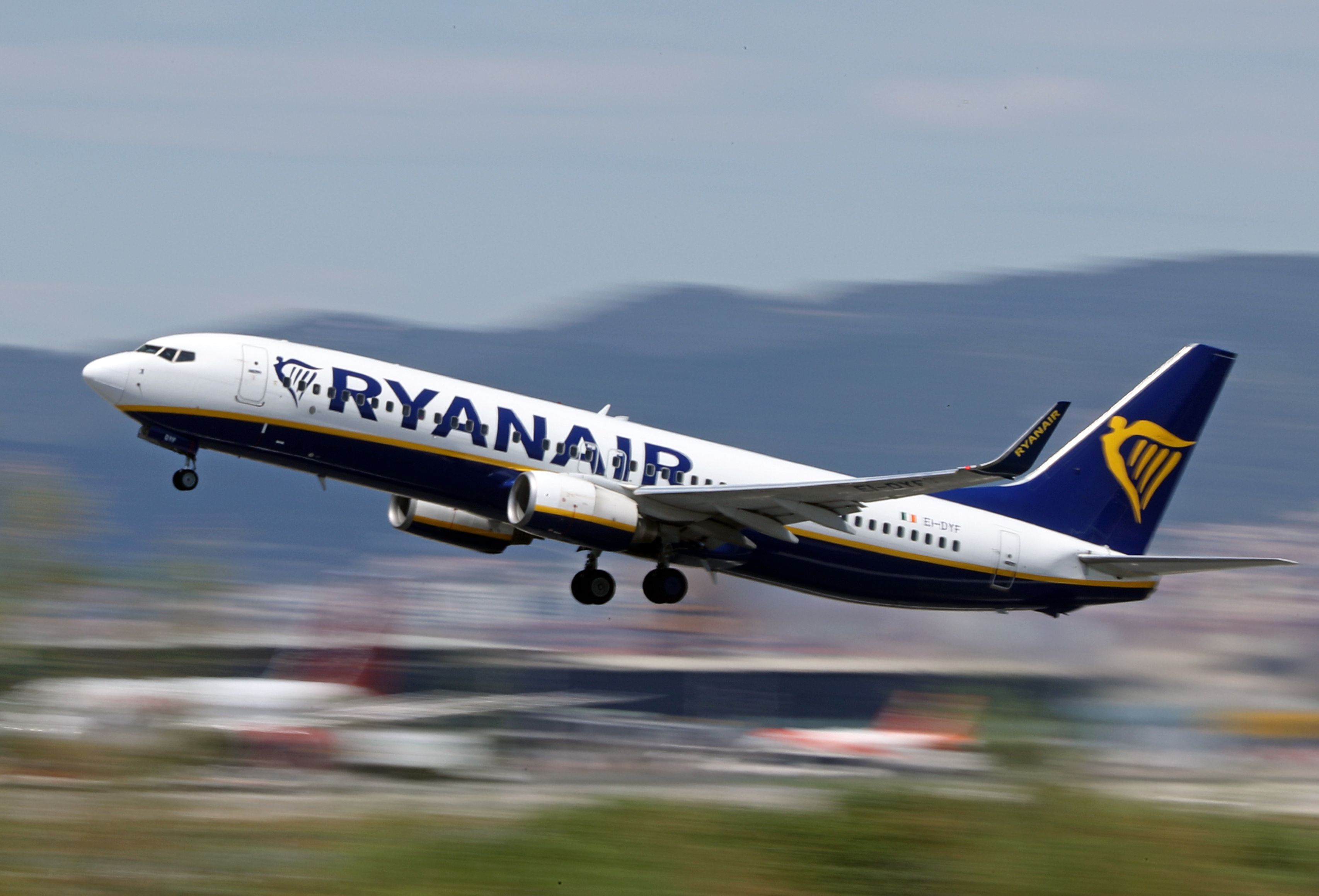 A Ryanair Boeing 737 is pictured taking off in front of a blurry background.