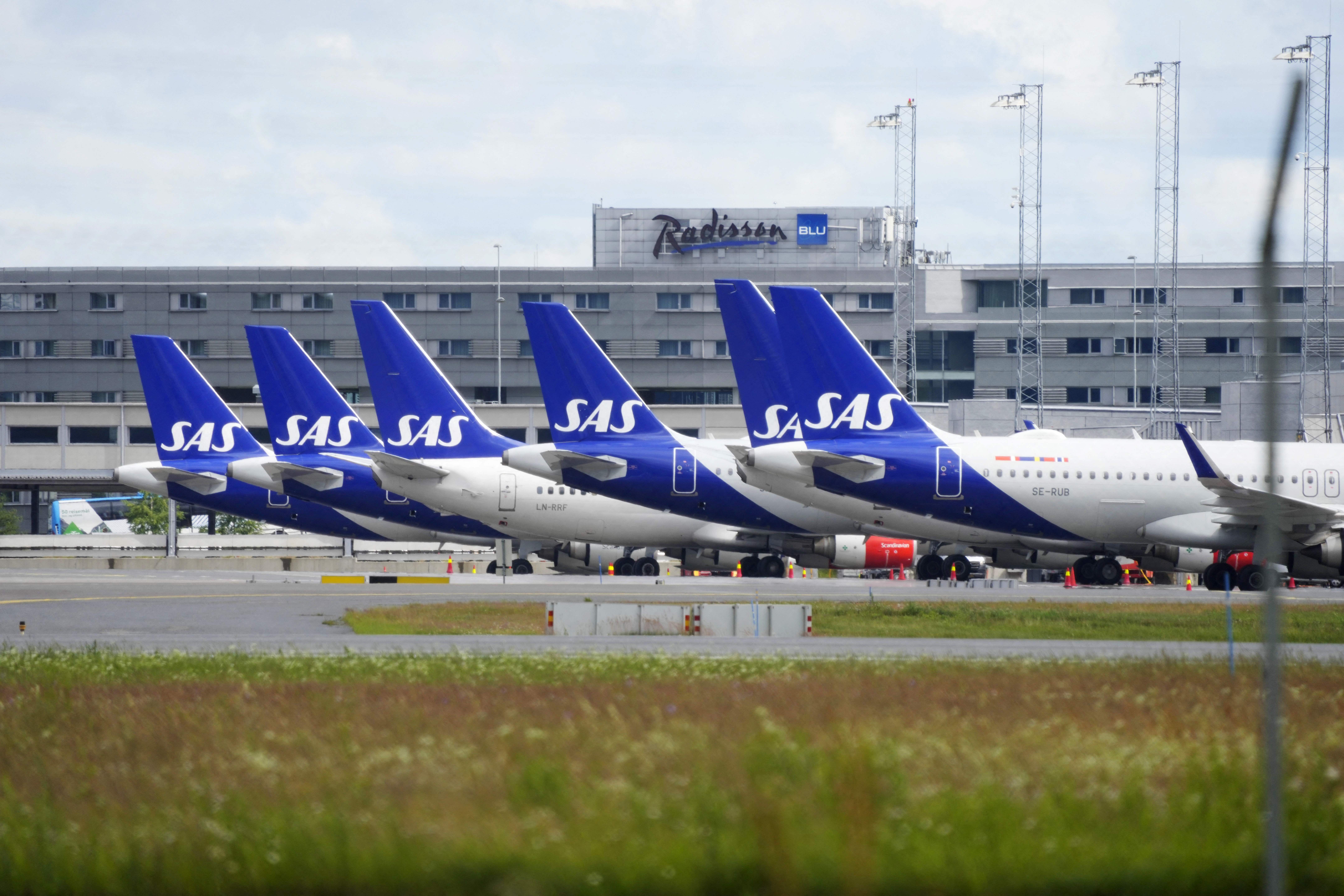 Planes of Scandinavian airline SAS sit on the tarmac in a row on July 4, 2022 at Oslo Airport Gardermoen.