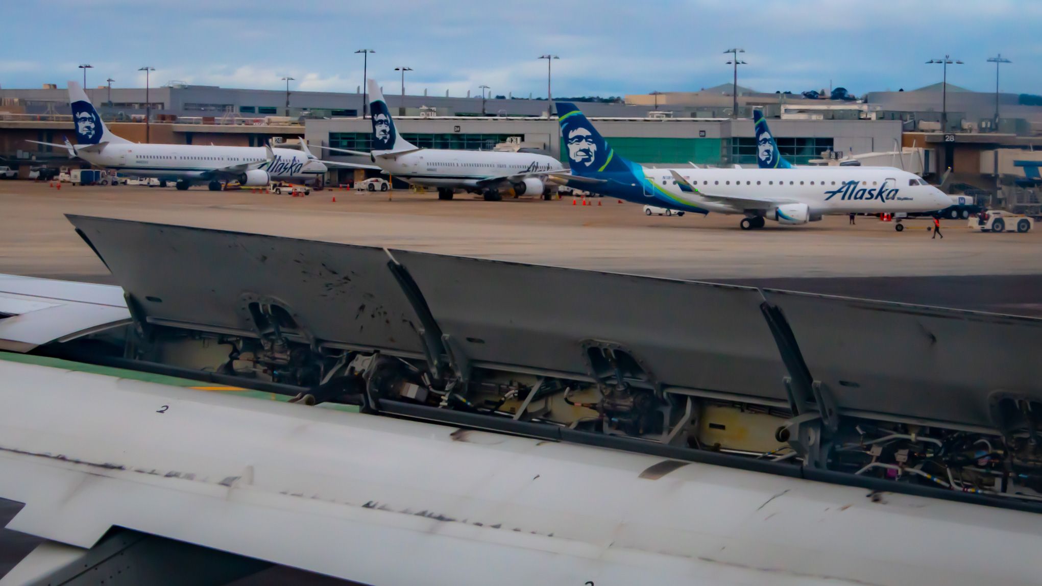 Peering Over the Deployed Speedbrake at Alaska Airlines Jets at the Gates - Boeing 737s and an Embraer 175