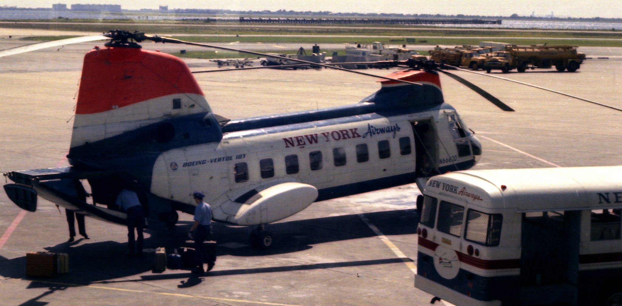 Ground crew members load cargo onto a New York Airways-branded helicopter