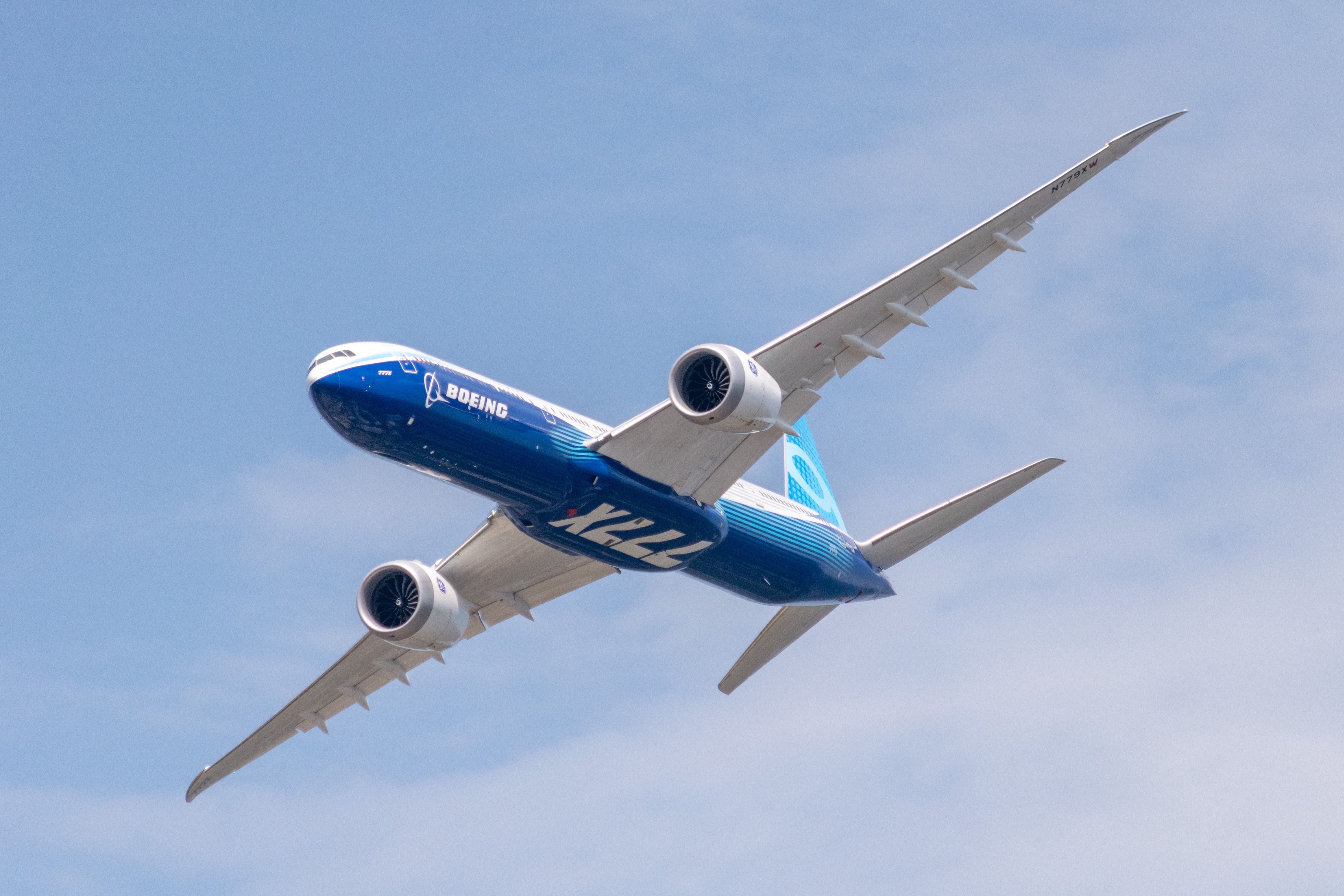 A Boeing 777X in the manufacturer's livery is seen flying at the 2022 Farnborough Airshow