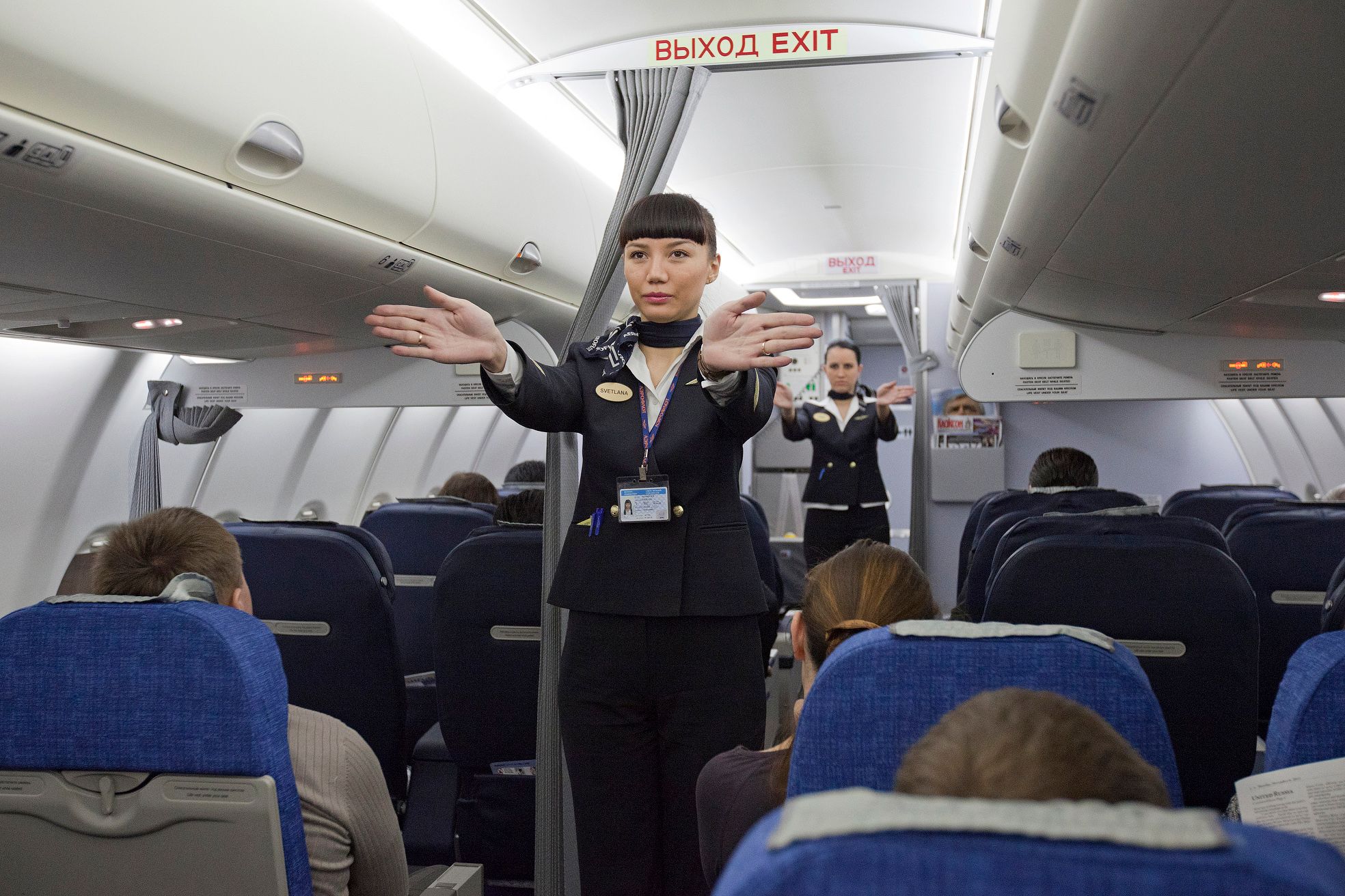 Aeroflot Flight attendant performing the flight safety briefing for passengers.