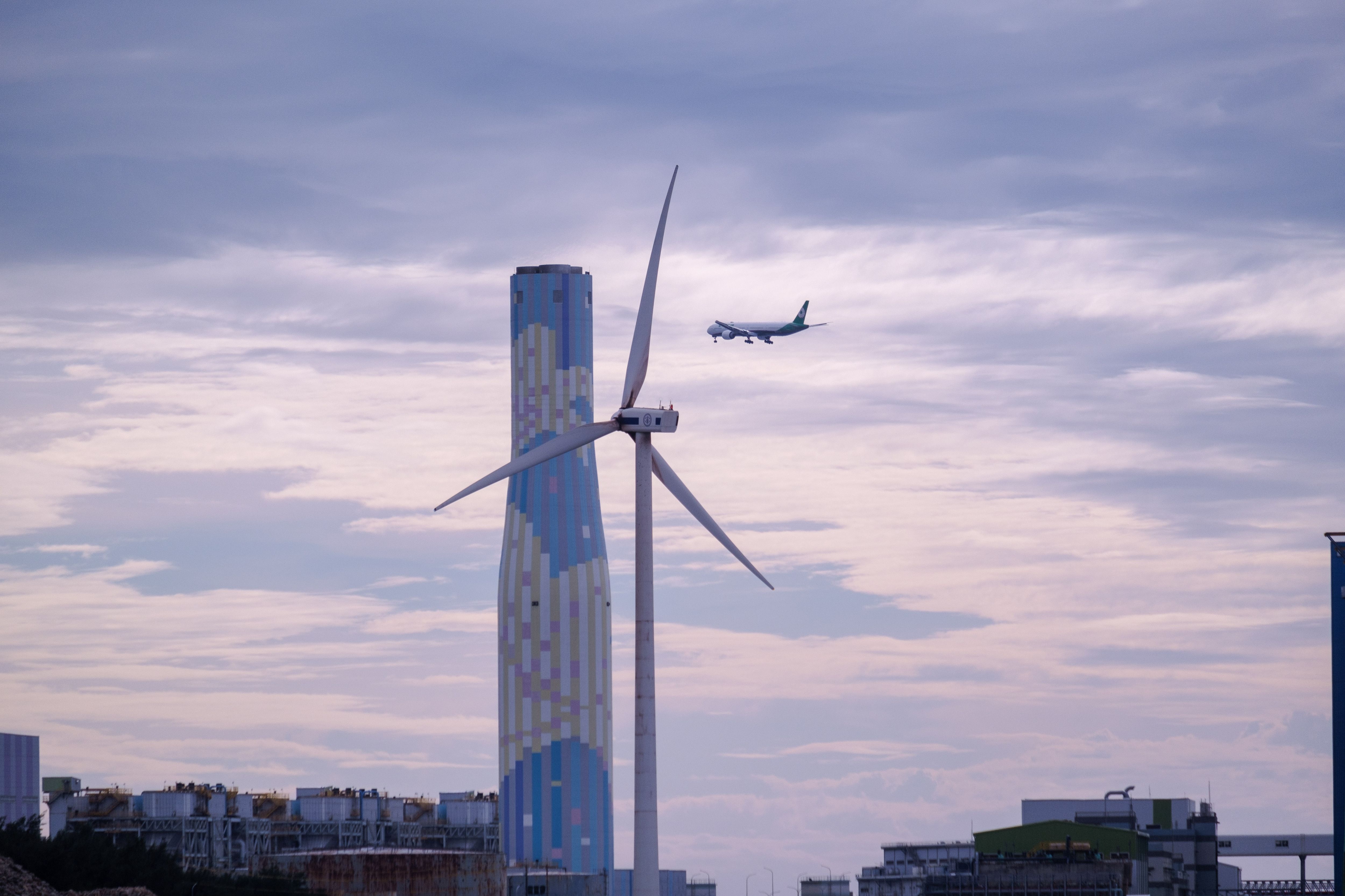 Wind turbine with aircraft landing in the background 
