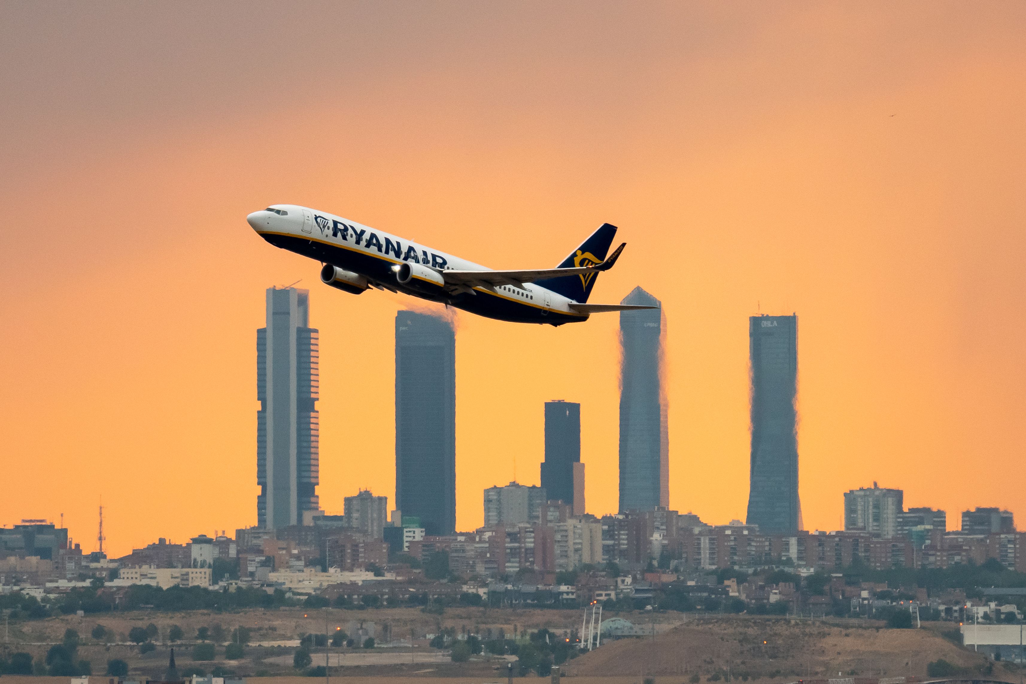 A Ryanair Boeing 737-800 takes off from Madrid at sunset.