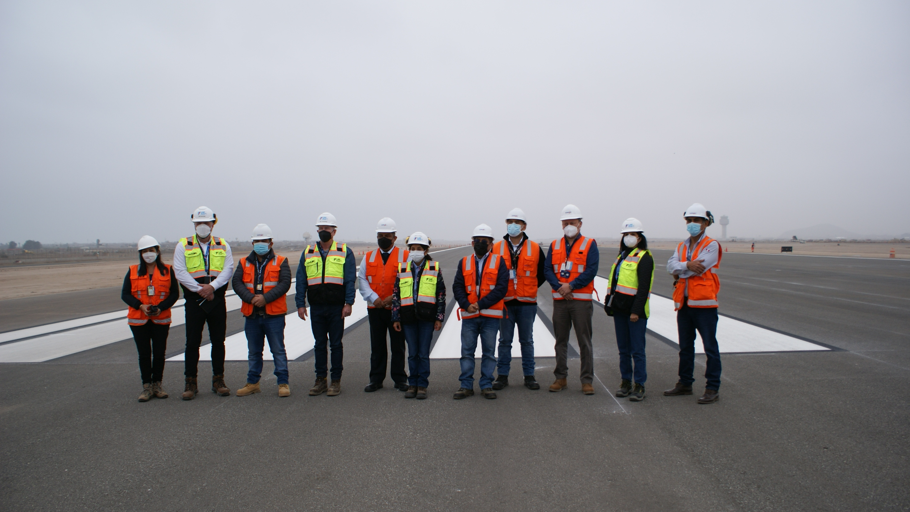 A view of Lima Airport runway with several workers.