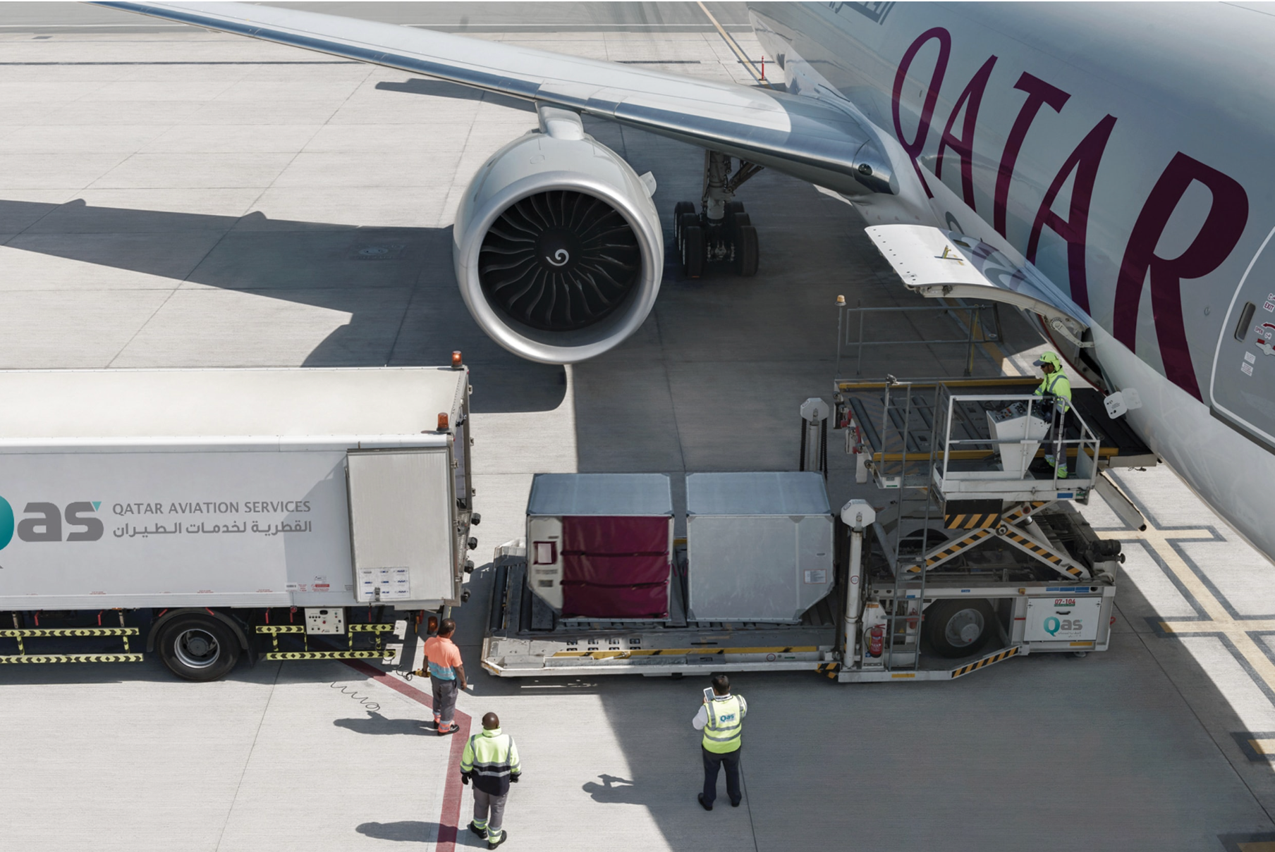 Ground handlers loading Qatar Airways plane 