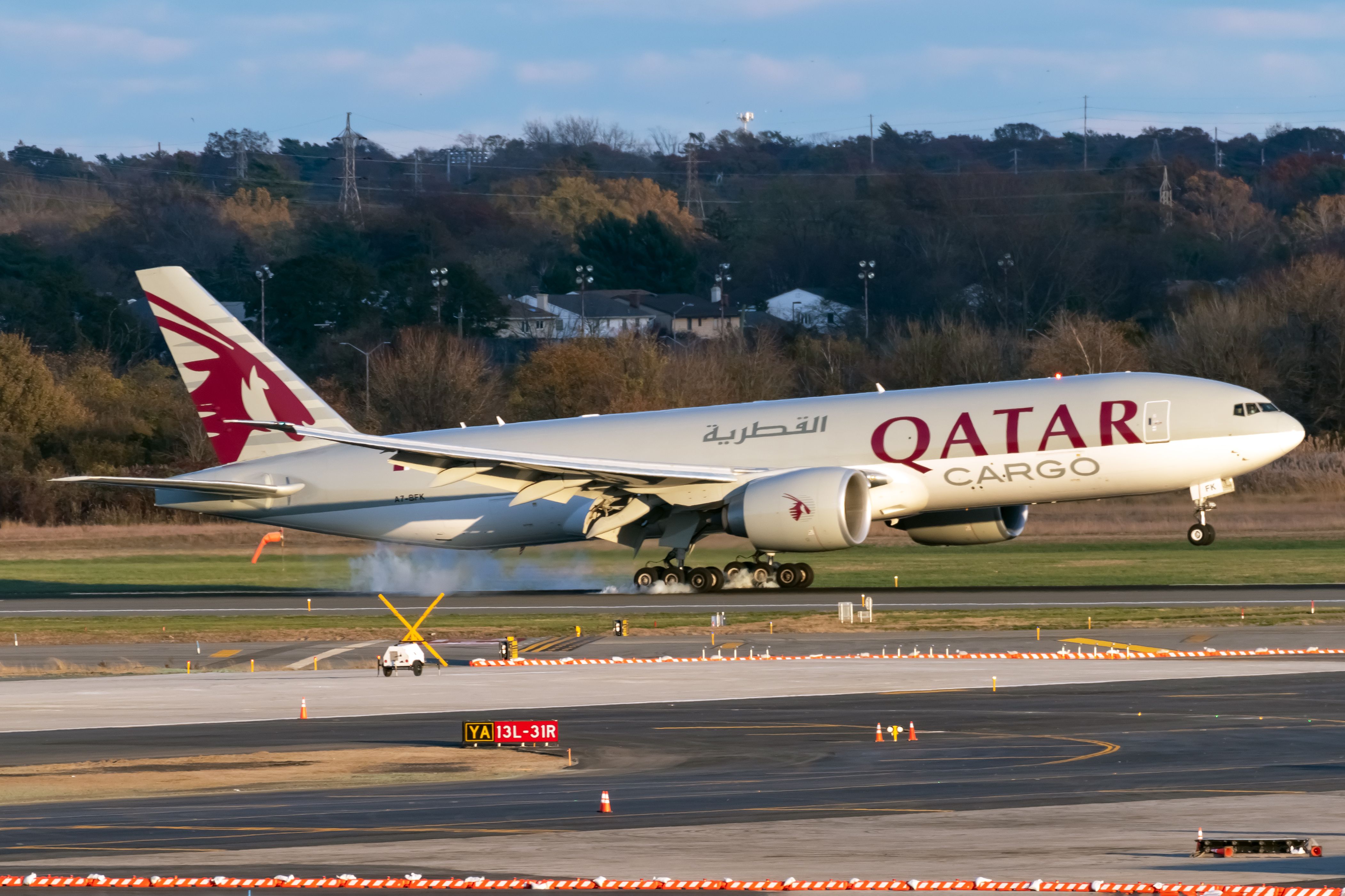A Qatar Airways Cargo Boeing 777 as it lands on a runway.